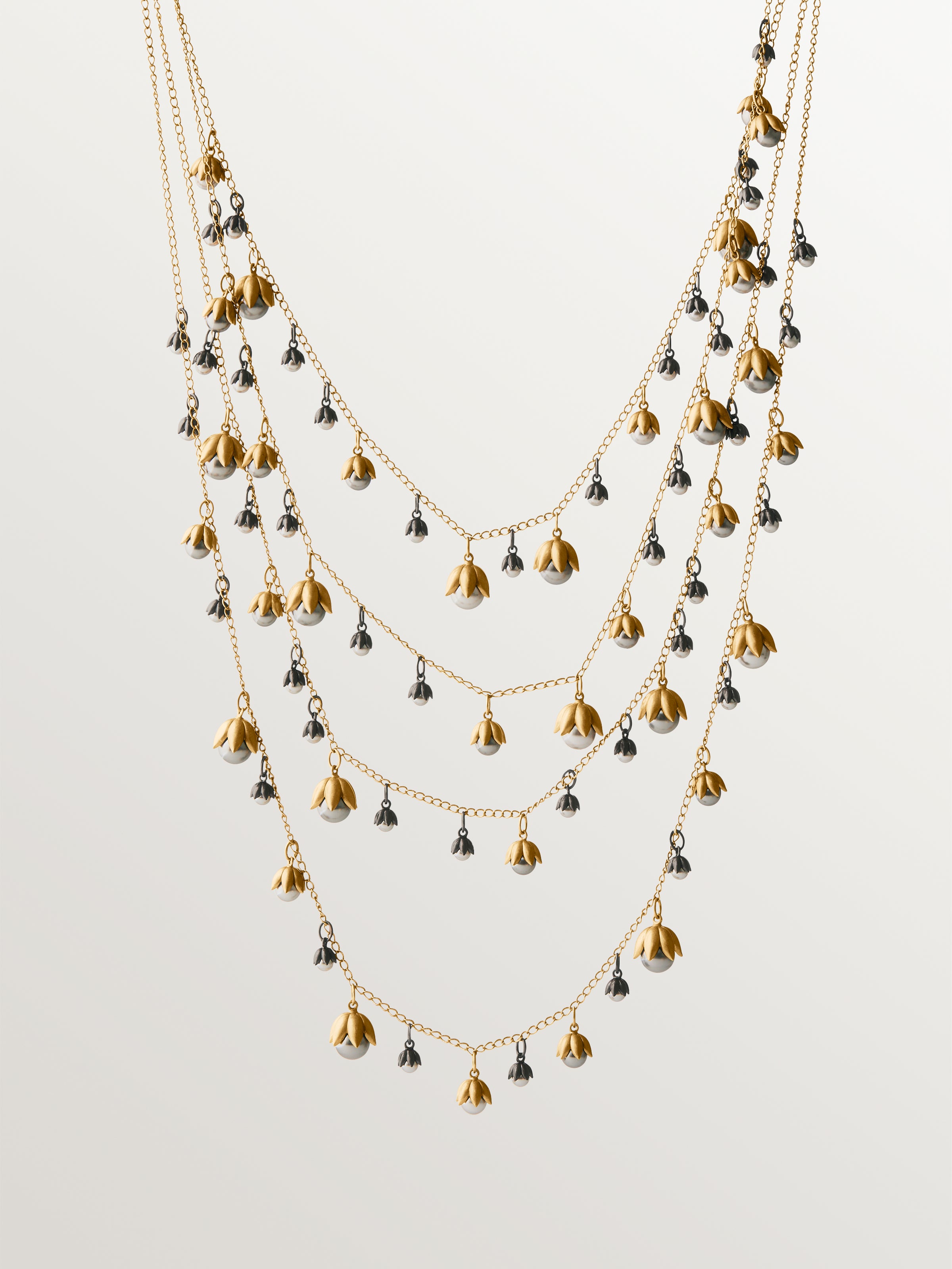 Collar bicolor bañado en oro amarillo y acabado gunmetal con perlas grises y motivos florales 