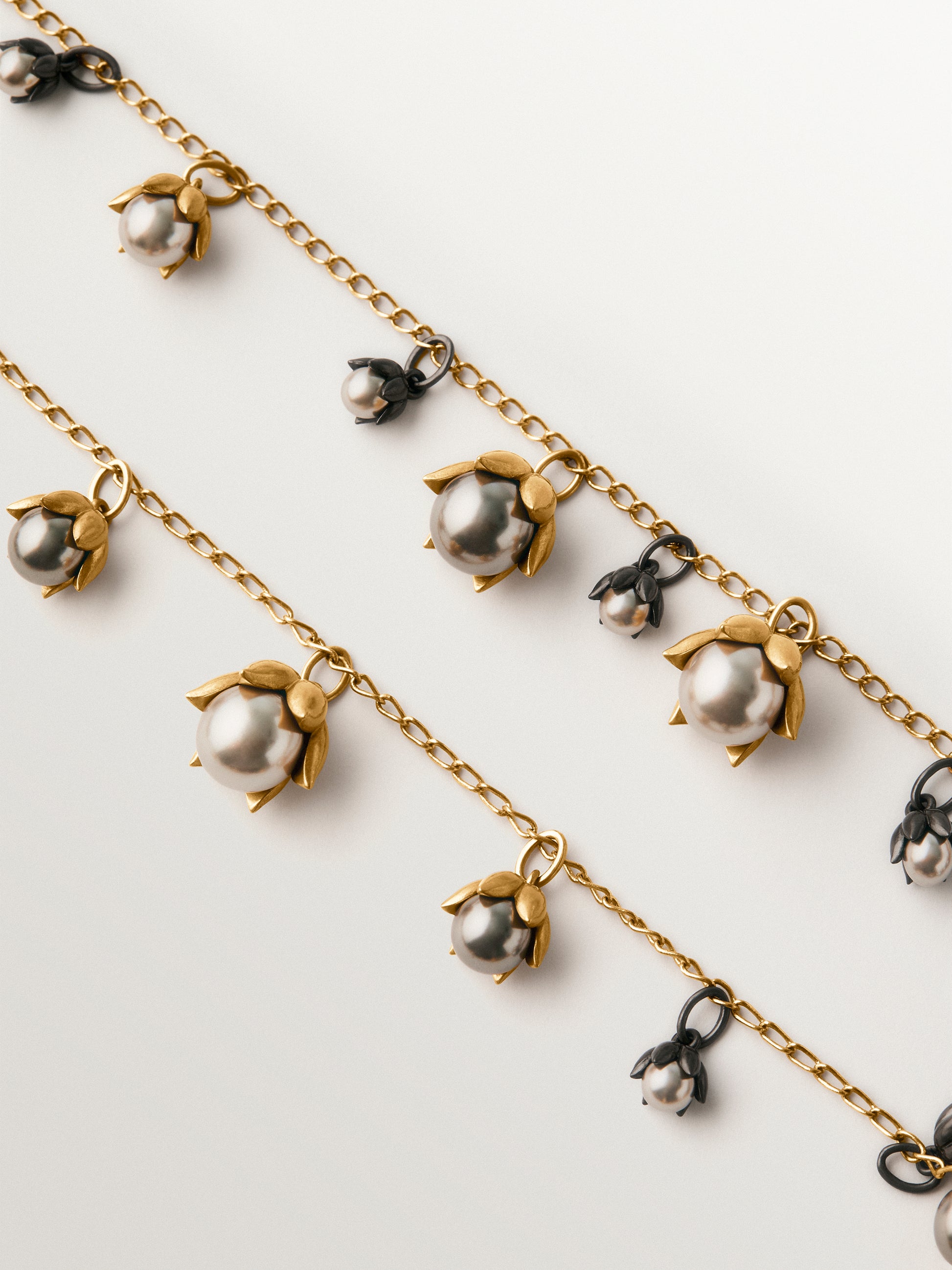 Collar bicolor bañado en oro amarillo y acabado gunmetal con perlas grises y motivos florales 