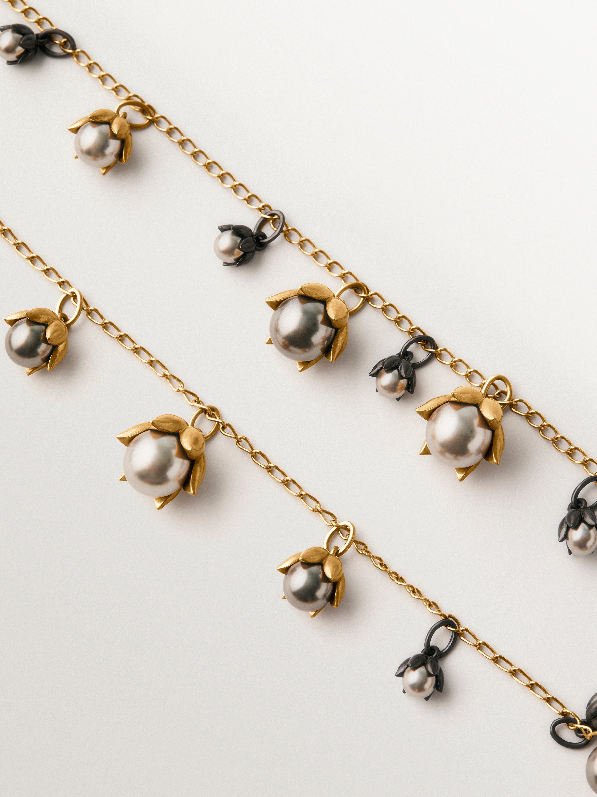 Collar bicolor bañado en oro amarillo y acabado gunmetal con perlas grises y motivos florales 