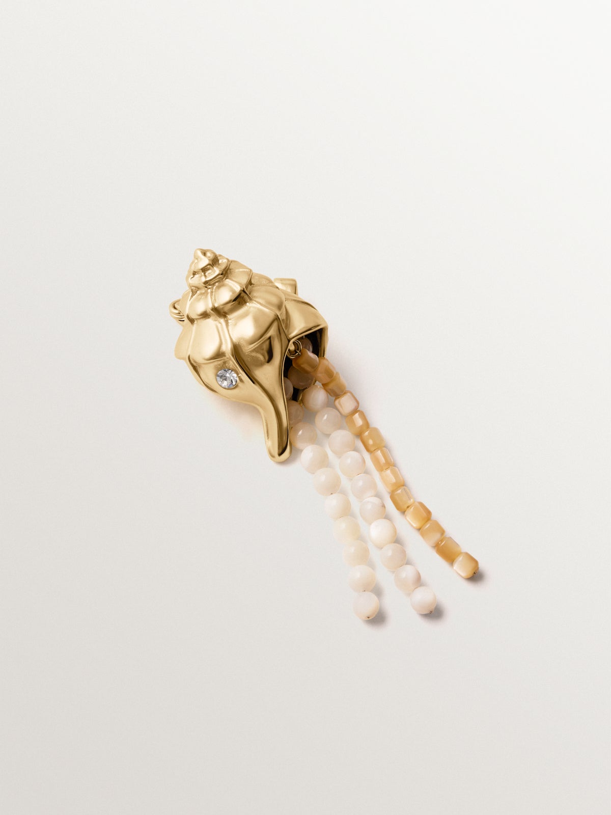 Broche bañado en oro amarillo con cristales, bolitas blancas y forma de concha