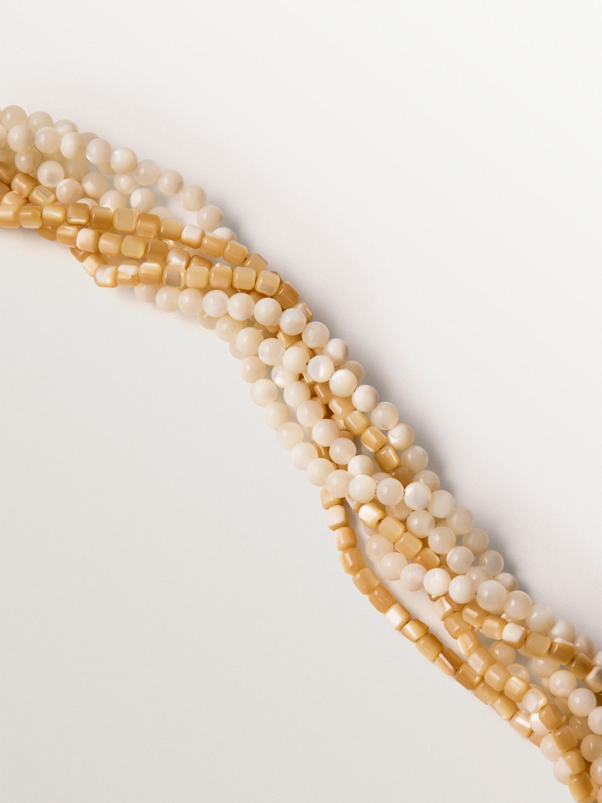 Collar bañado en oro amarillo con cristales, bolitas blancas y forma de concha