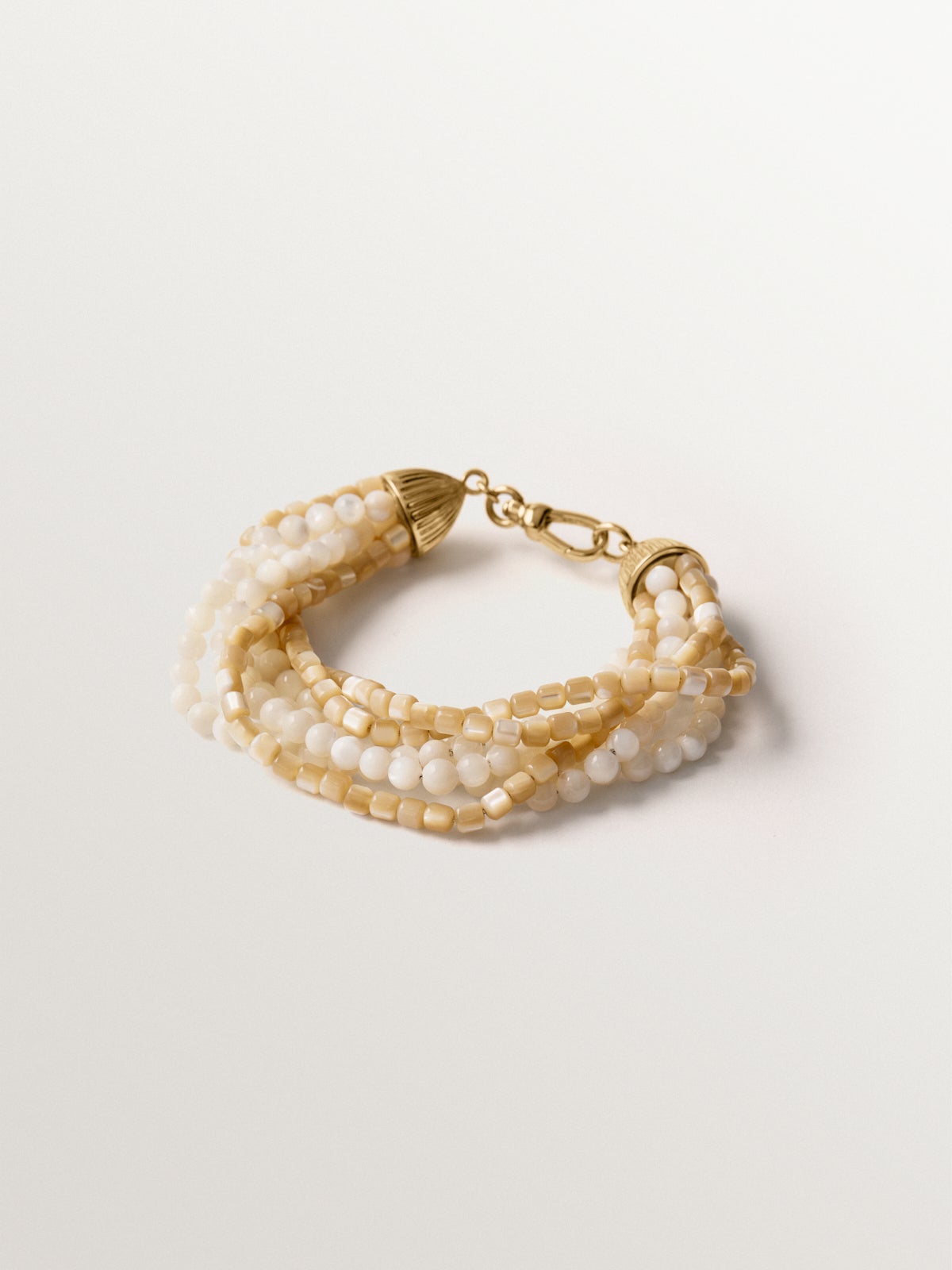 Pulsera bañada en oro amarillo con bolitas blancas y crema