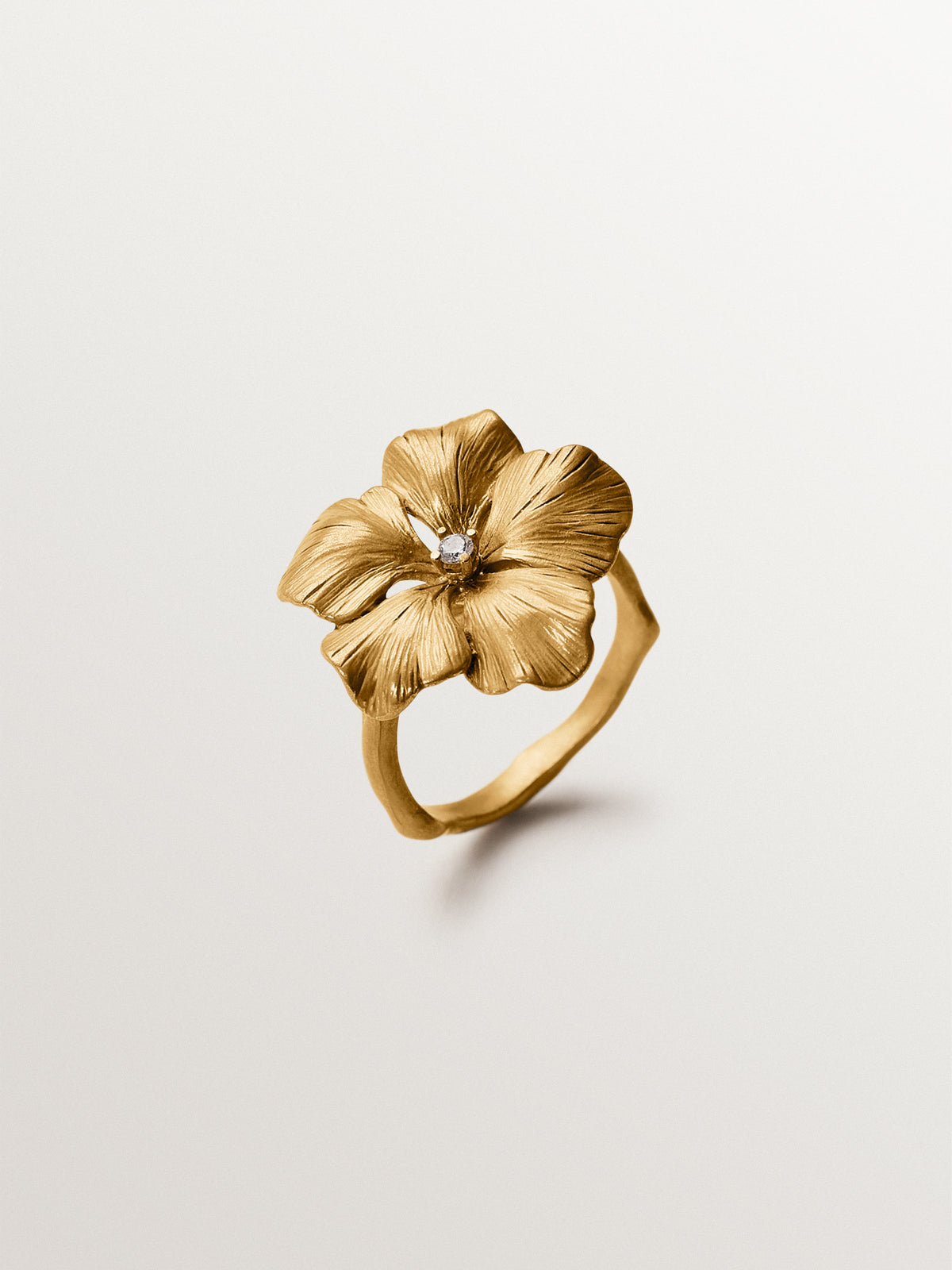 Anillo bañado en oro amarillo con cristal y forma de flor