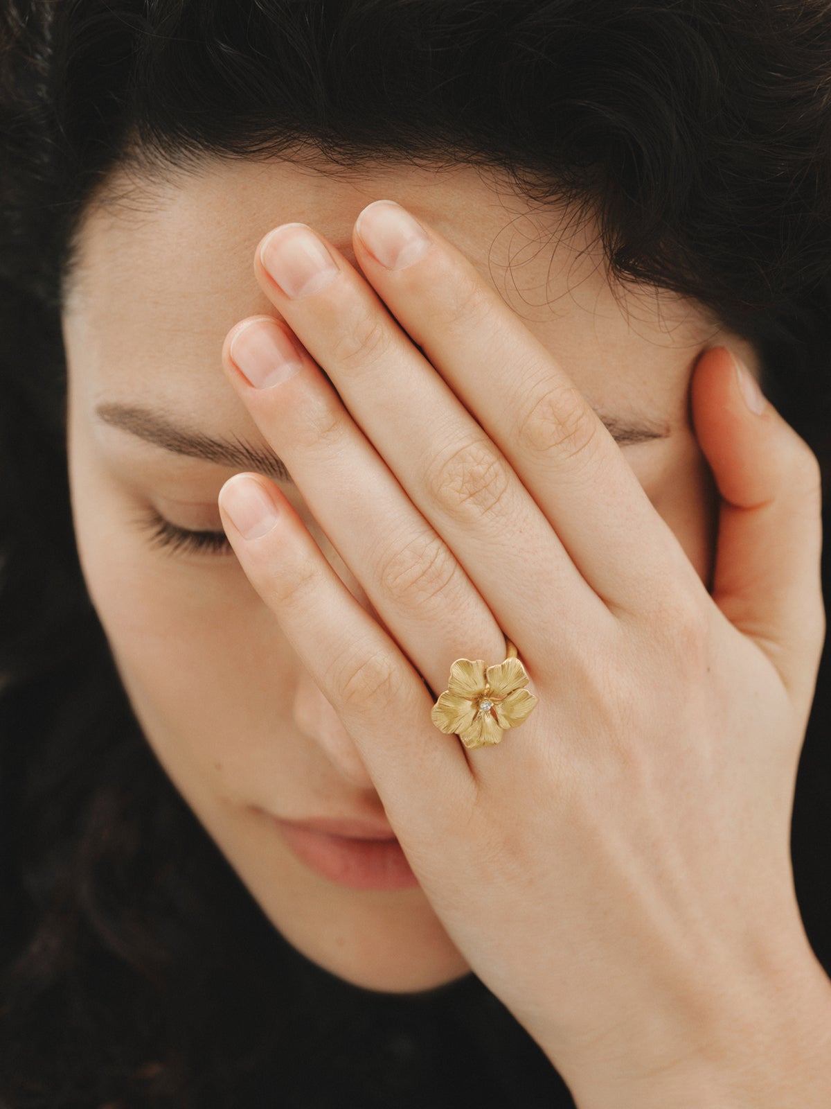 Anillo bañado en oro amarillo con cristal y forma de flor