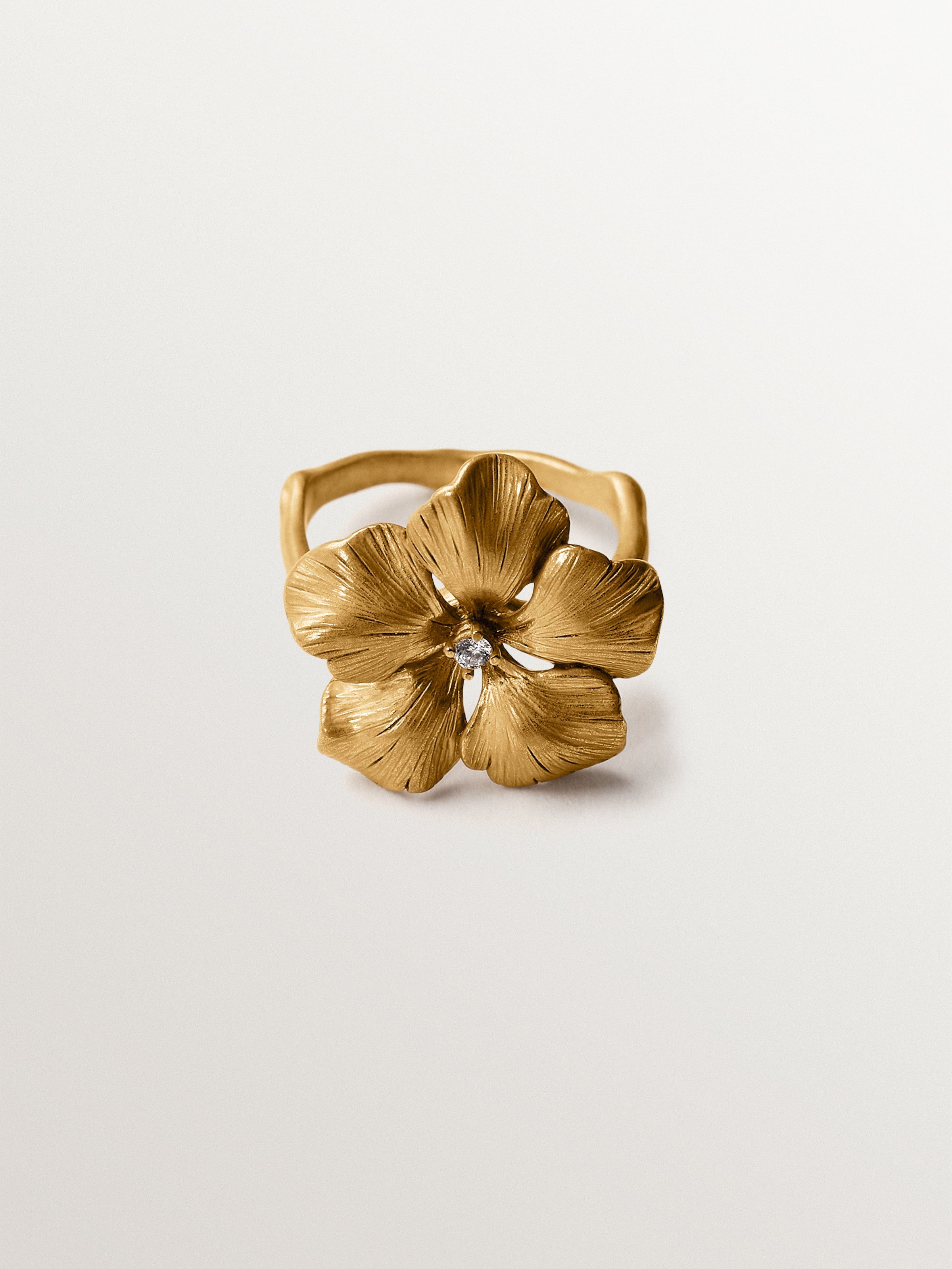 Anillo bañado en oro amarillo con cristal y forma de flor