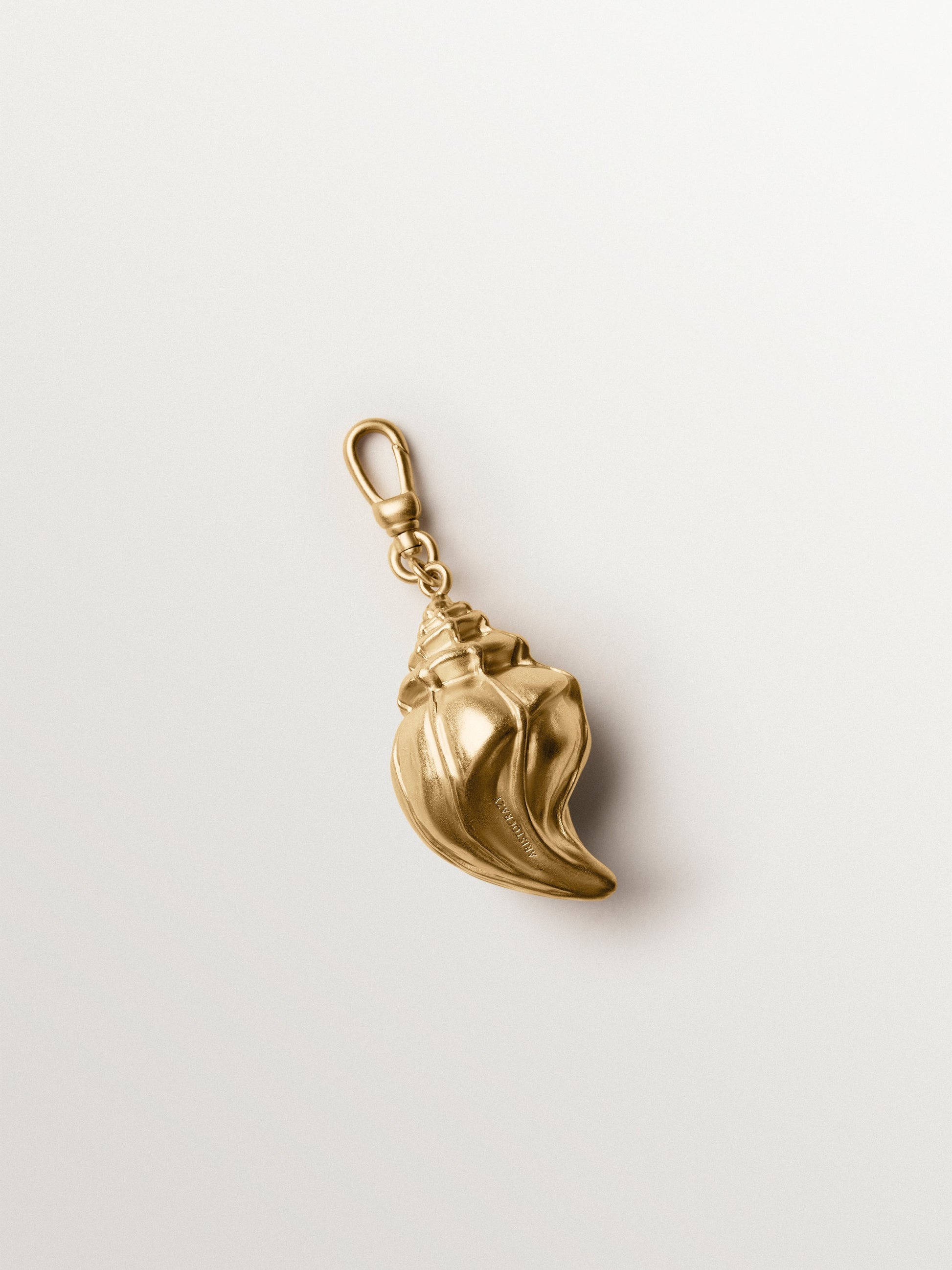 Charm bañado en oro amarillo con cristales y forma de concha