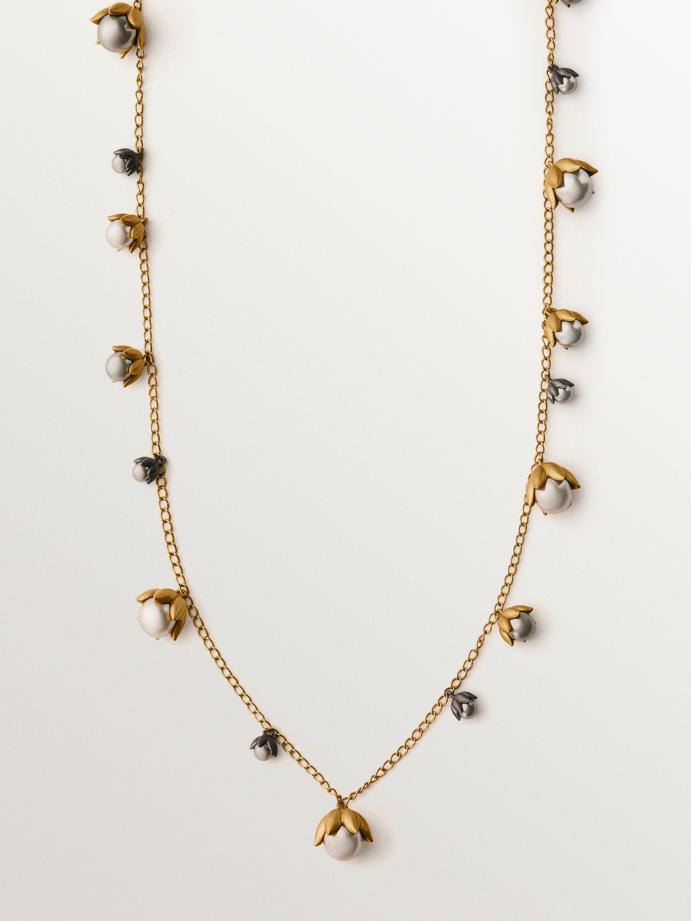 Colgante bicolor bañado en oro amarillo y acabado gunmetal con perlas grises y motivos florales