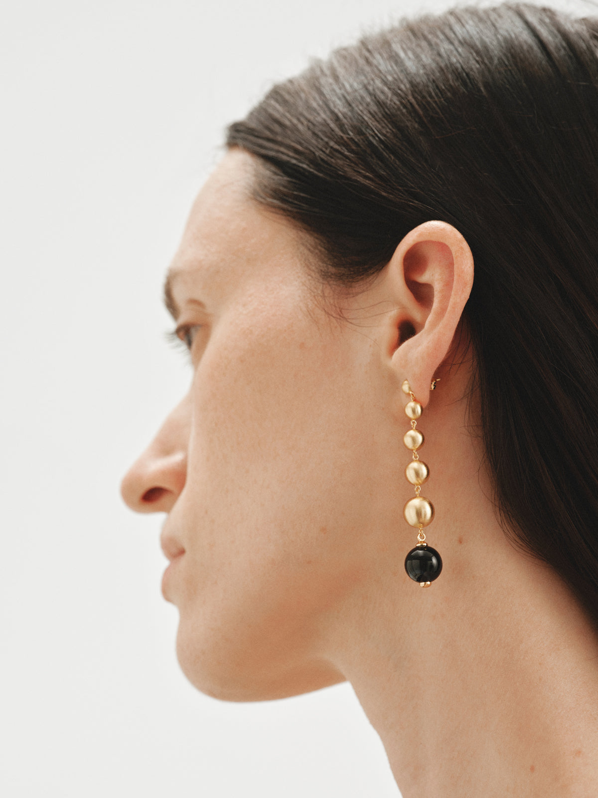 Pendientes largos bañados en oro amarillo con efecto cepillado, ágata negra y motivos de esferas