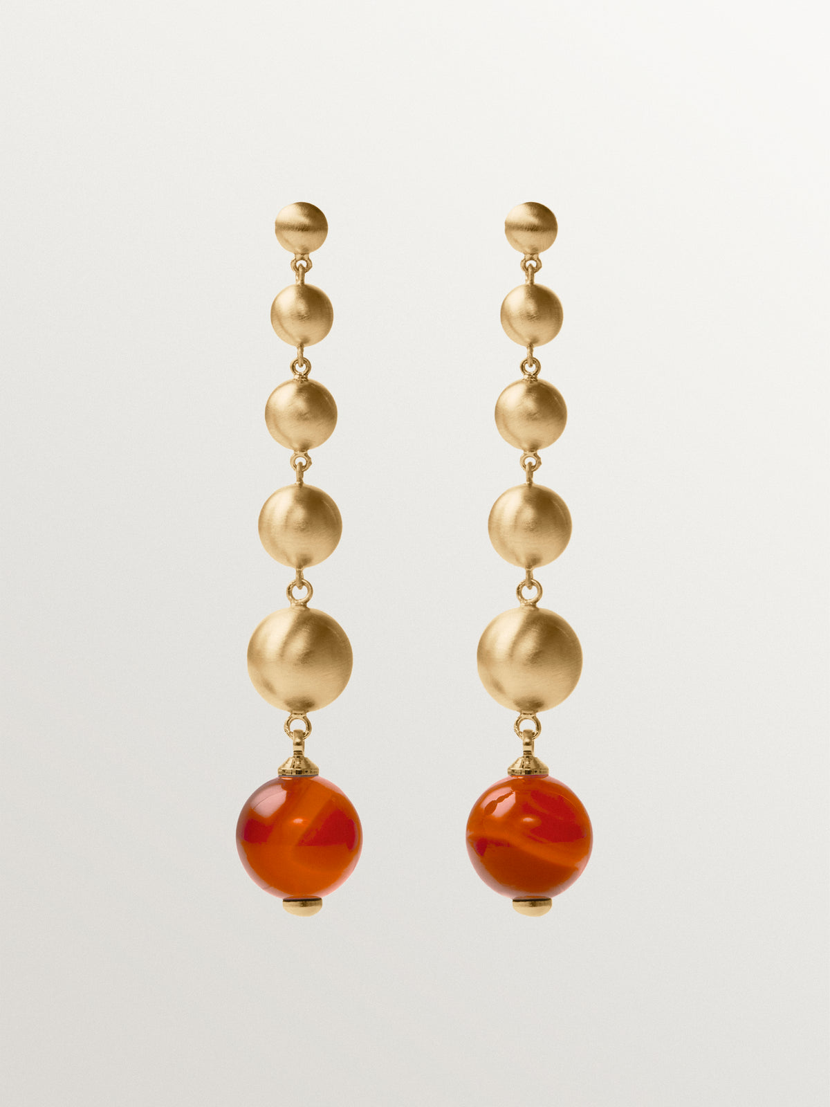 Pendientes largos bañados en oro amarillo con efecto cepillado, ágata roja y motivos de esferas