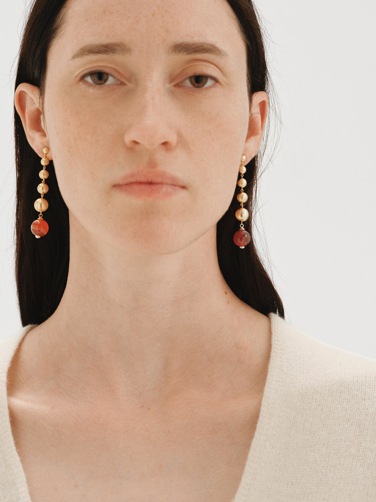 Pendientes largos bañados en oro amarillo con efecto cepillado, ágata roja y motivos de esferas