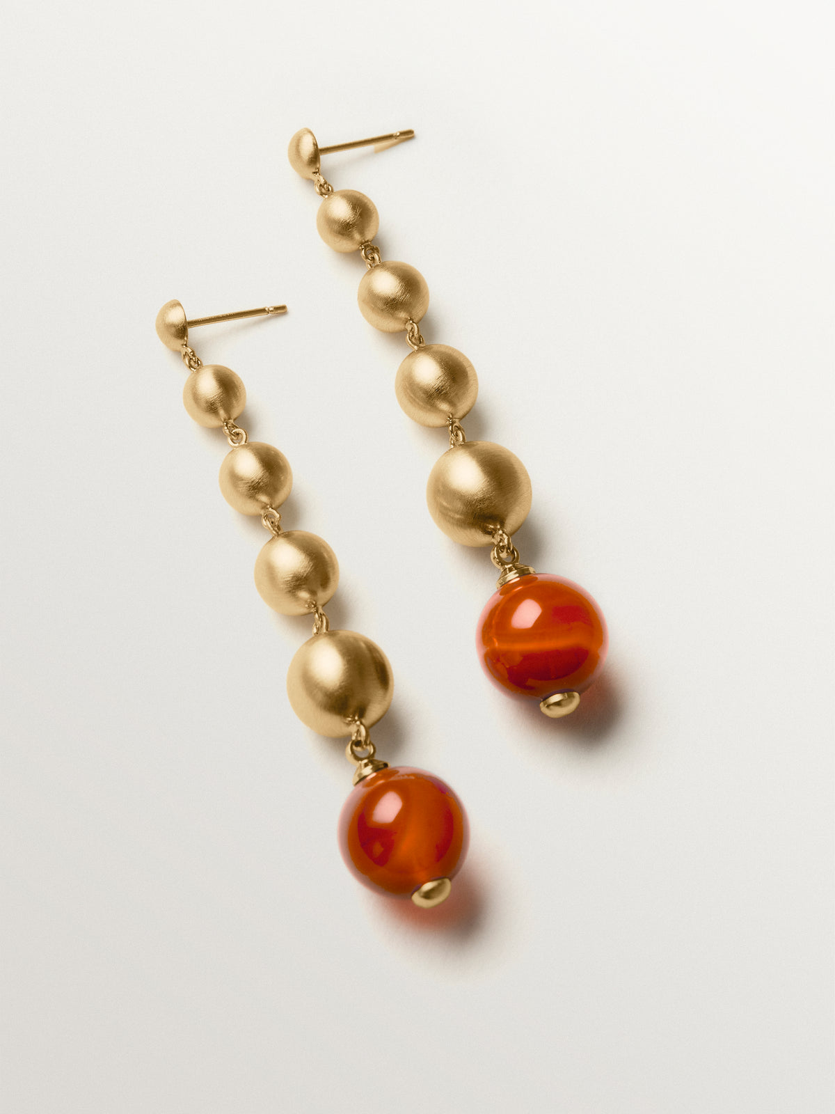 Pendientes largos bañados en oro amarillo con efecto cepillado, ágata roja y motivos de esferas