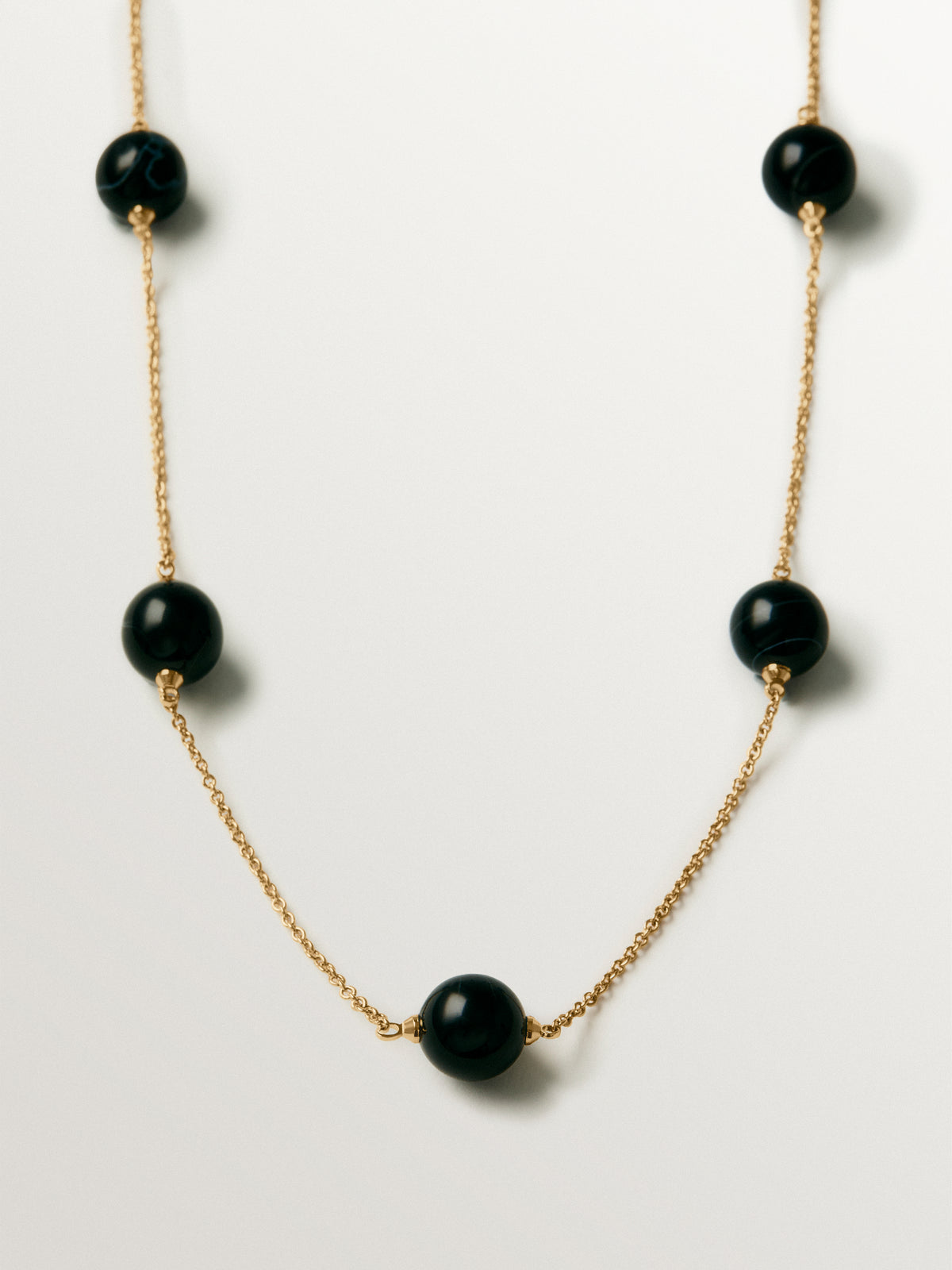 Collar bañado en oro amarillo con efecto cepillado, ágata negra y motivo de esferas