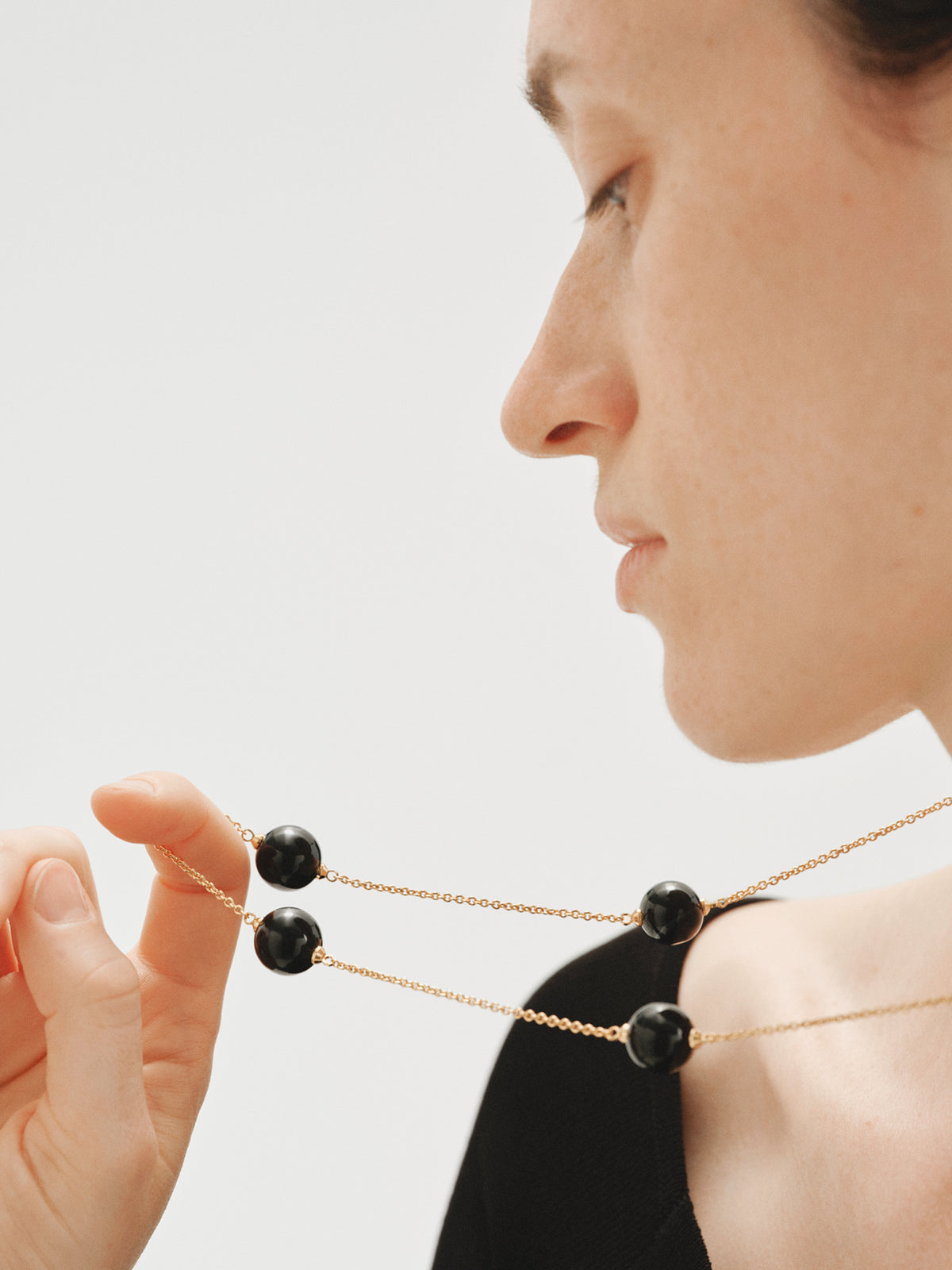 Collar bañado en oro amarillo con efecto cepillado, ágata negra y motivo de esferas