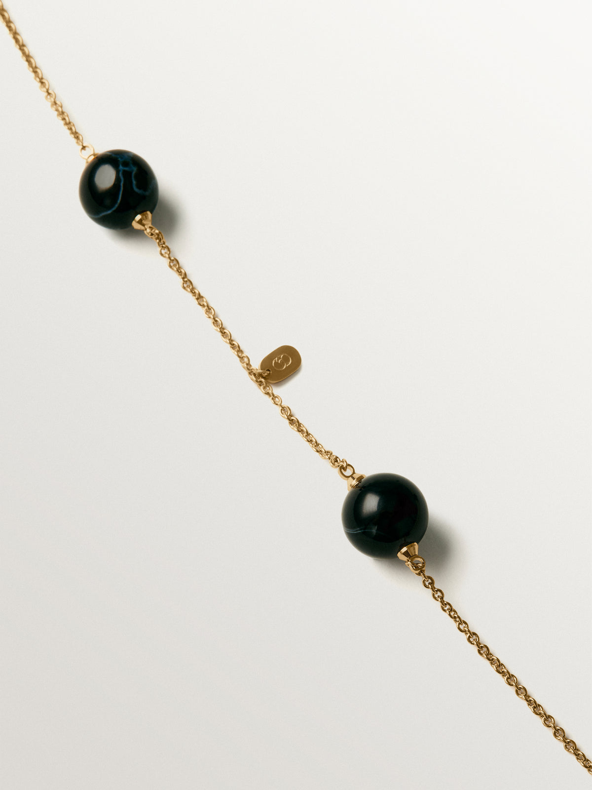 Collar bañado en oro amarillo con efecto cepillado, ágata negra y motivo de esferas