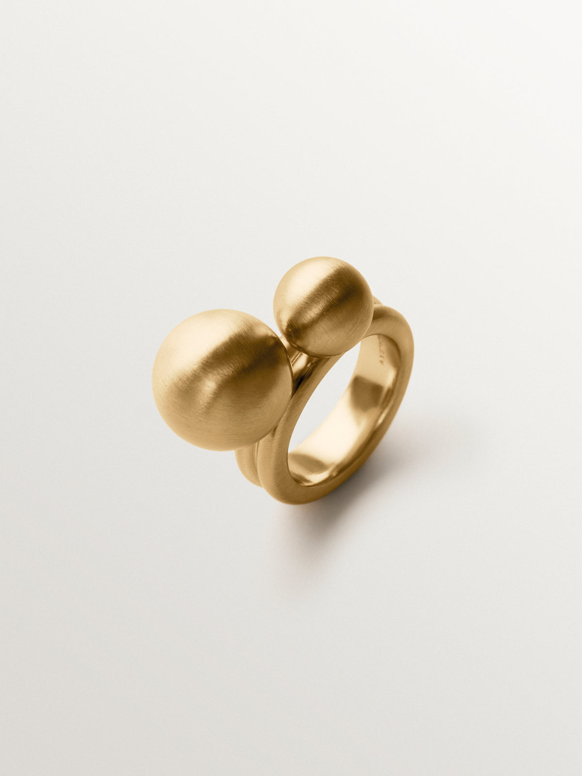 Anillo bañado en oro amarillo con efecto cepillado y motivo de dos esferas