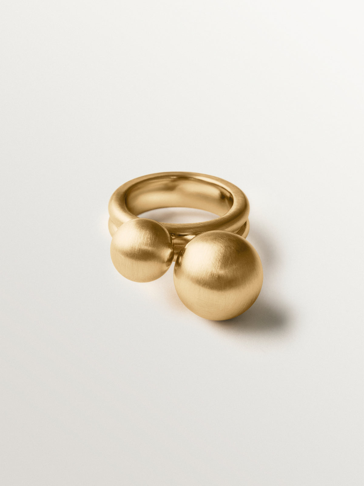 Anillo bañado en oro amarillo con efecto cepillado y motivo de dos esferas
