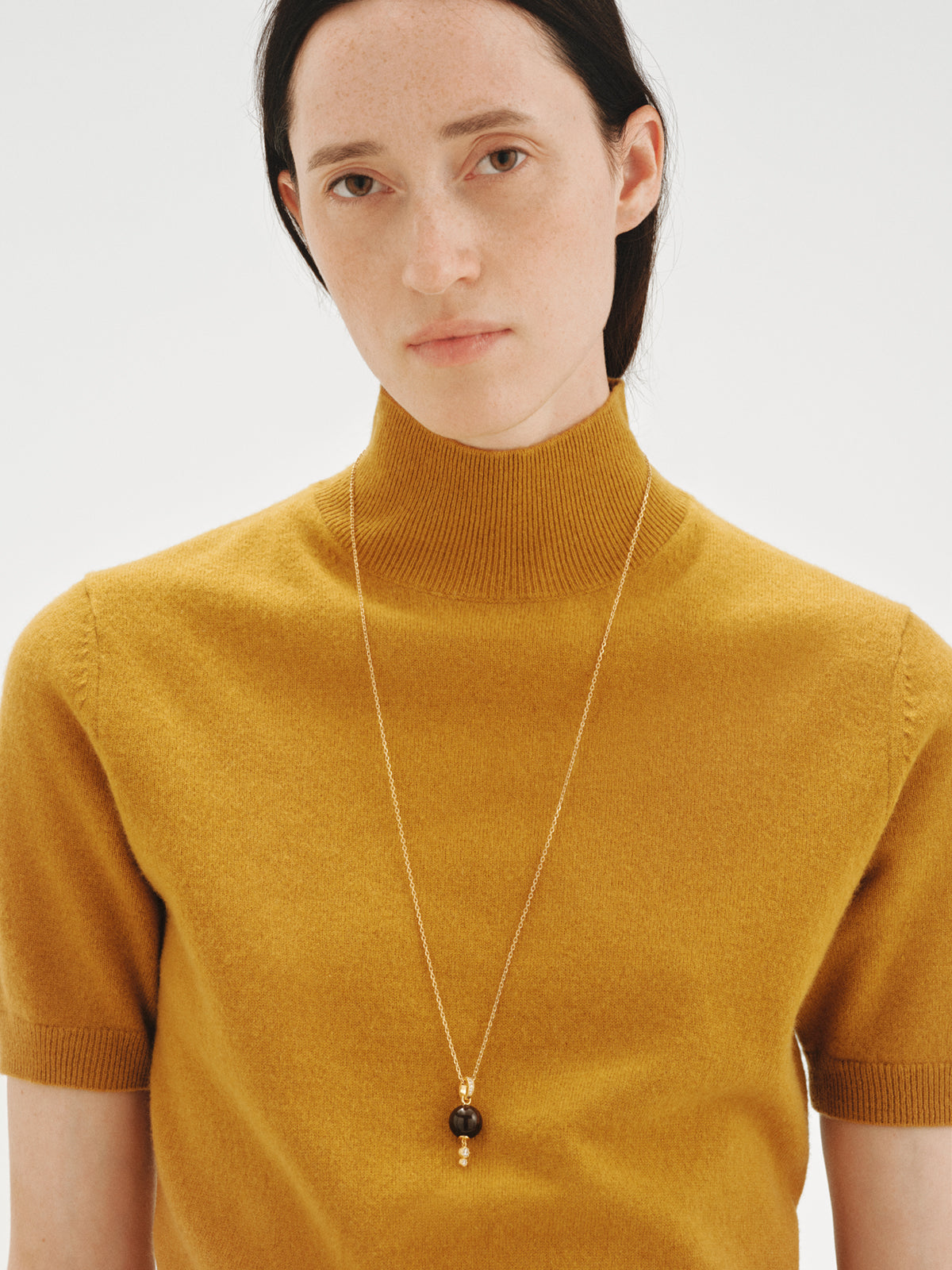 Charm bañado en oro amarillo de 18K con resina marrón, cristales y motivo de esfera