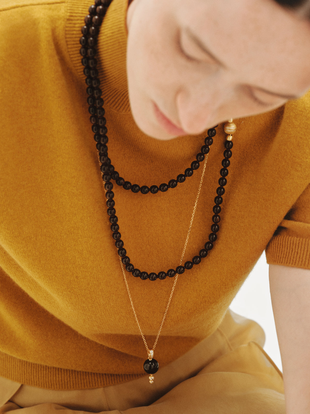 Charm bañado en oro amarillo de 18K con resina marrón, cristales y motivo de esfera