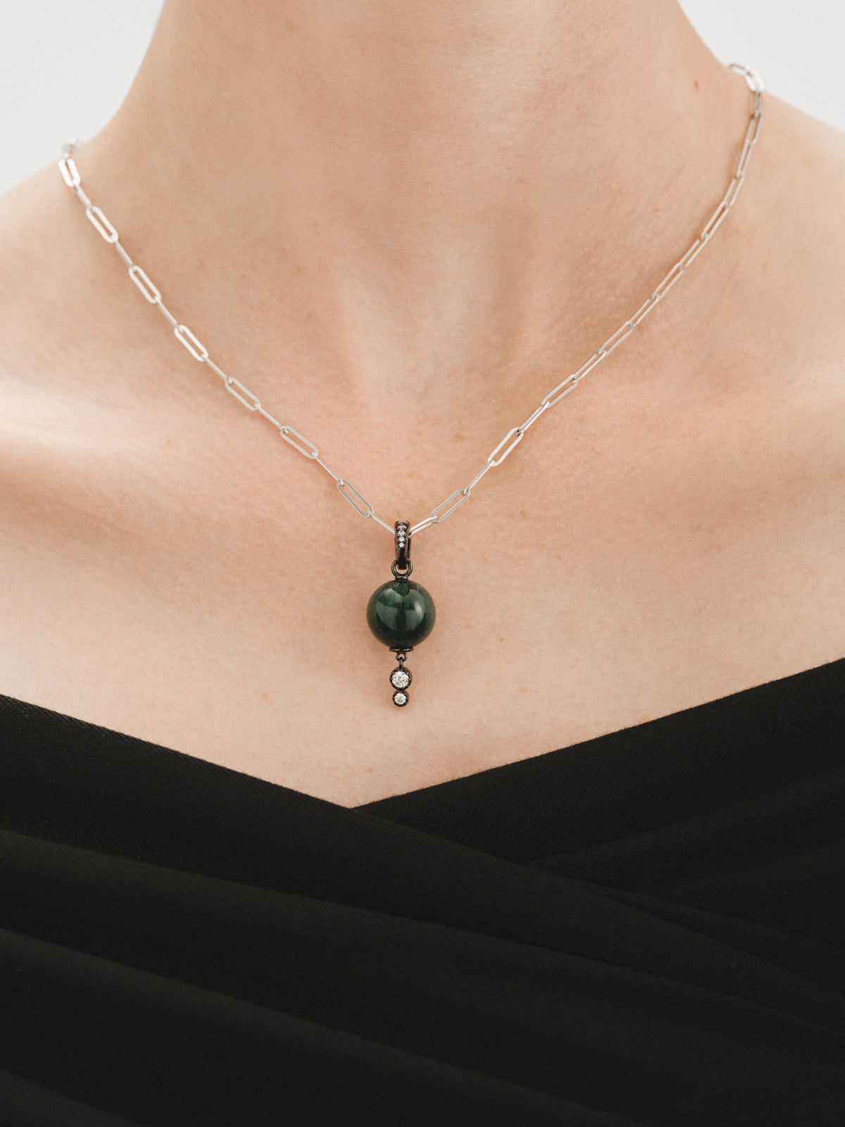 Charm con acabado gunmetal con resina verde, cristales y motivo de esfera