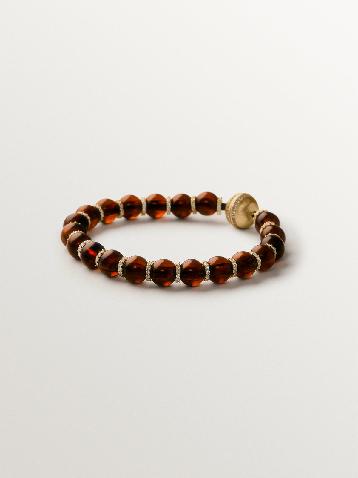 Pulsera bañada en oro amarillo de 18K con resina marrón, cristales y motivos de esferas
