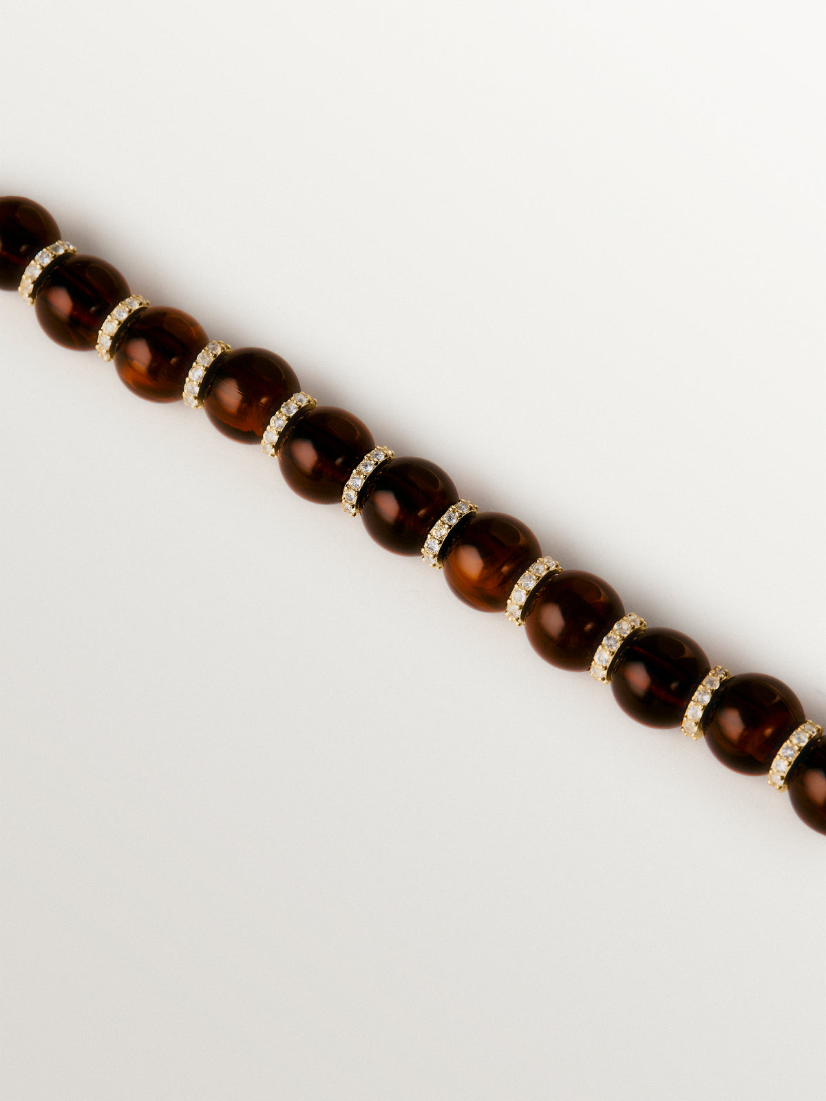 Pulsera bañada en oro amarillo de 18K con resina marrón, cristales y motivos de esferas
