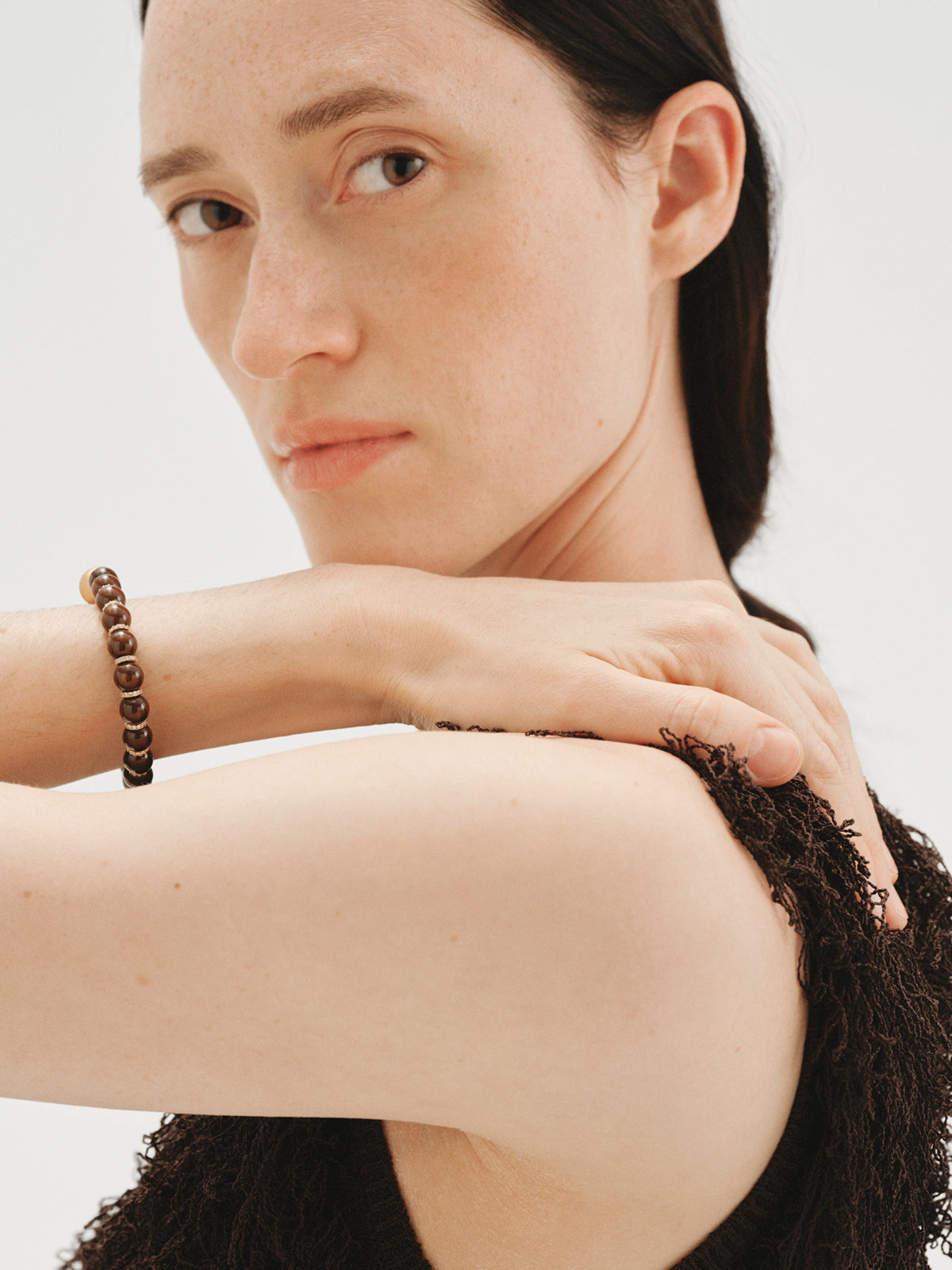 Pulsera bañada en oro amarillo de 18K con resina marrón, cristales y motivos de esferas