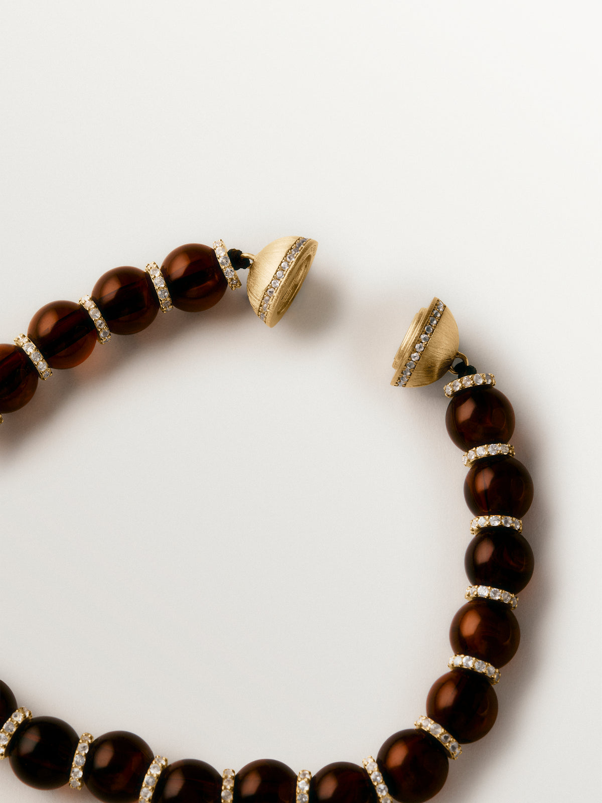Pulsera bañada en oro amarillo de 18K con resina marrón, cristales y motivos de esferas