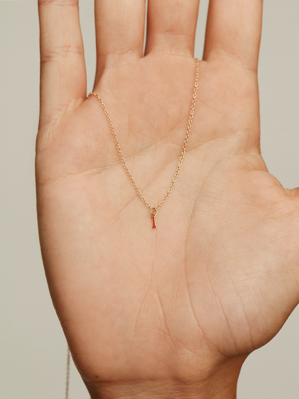 Charm de oro amarillo de 14K con número 1 en color rojo