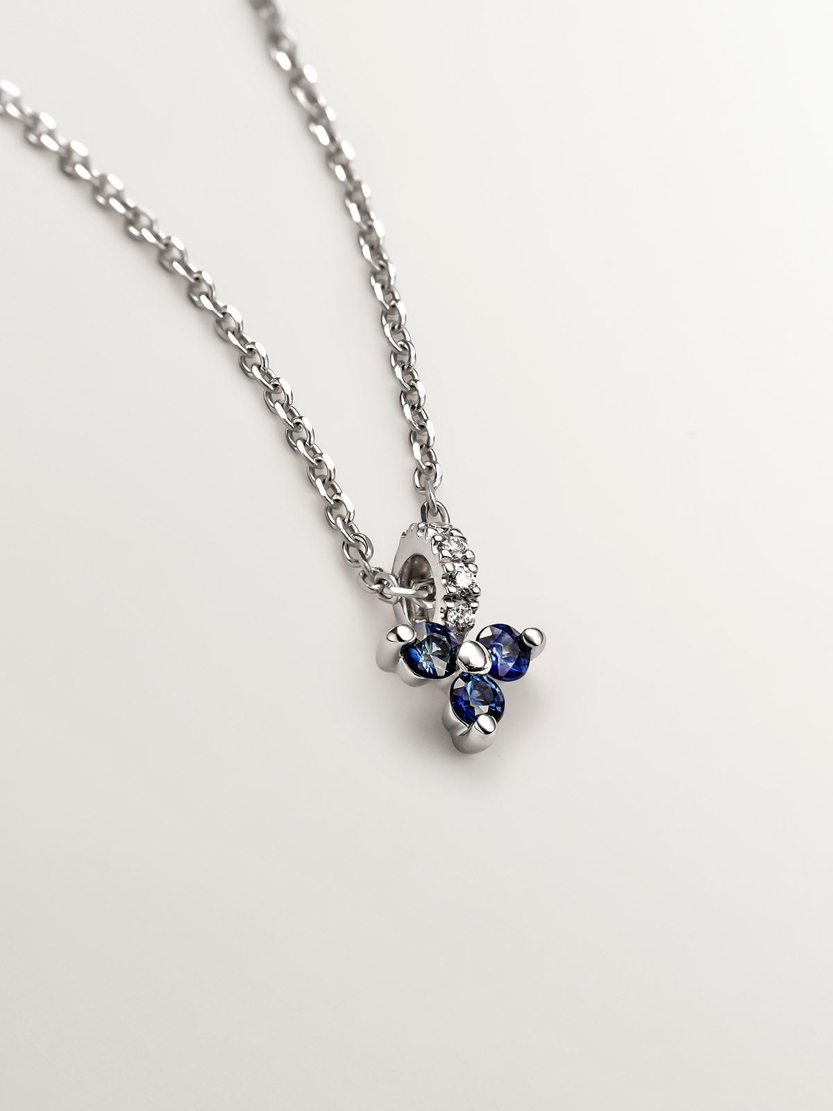 Colgante de oro blanco de 9K con zafiros azules y diamantes