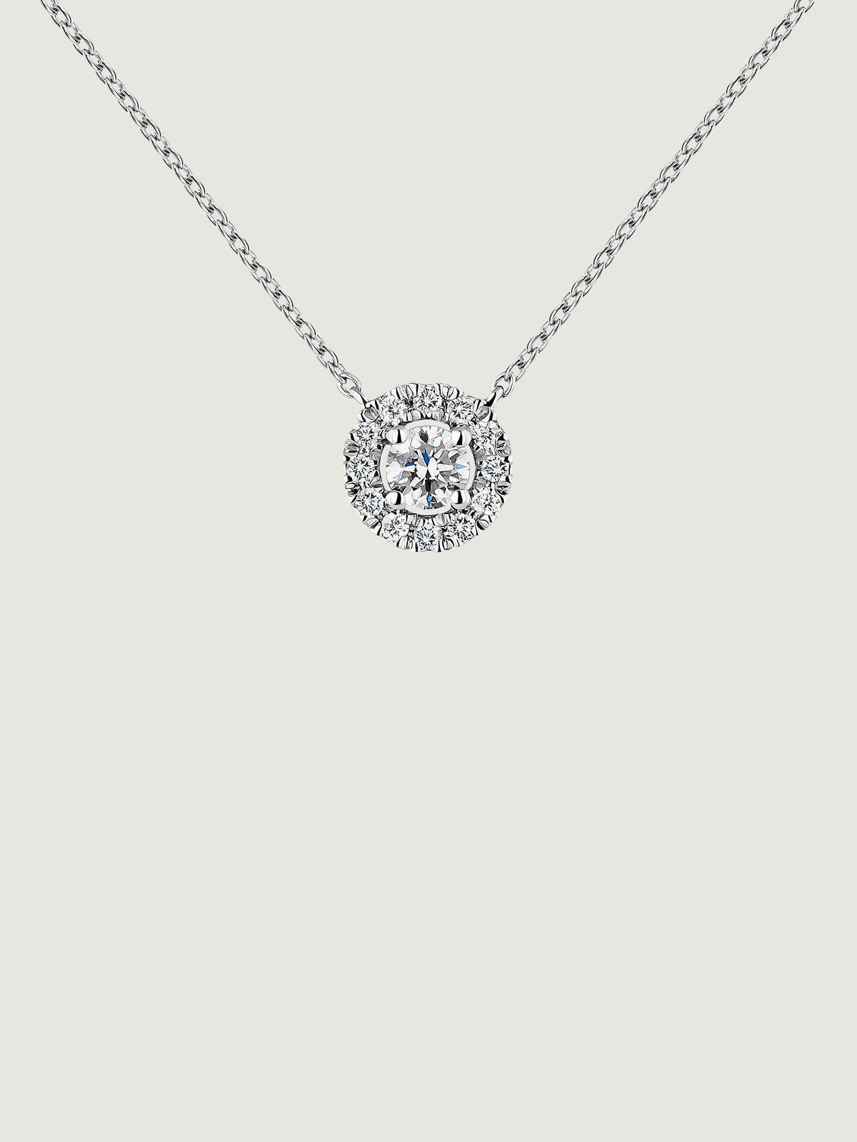 Colgante de oro blanco de 18K con diamante de 0,11cts y orla de diamantes
