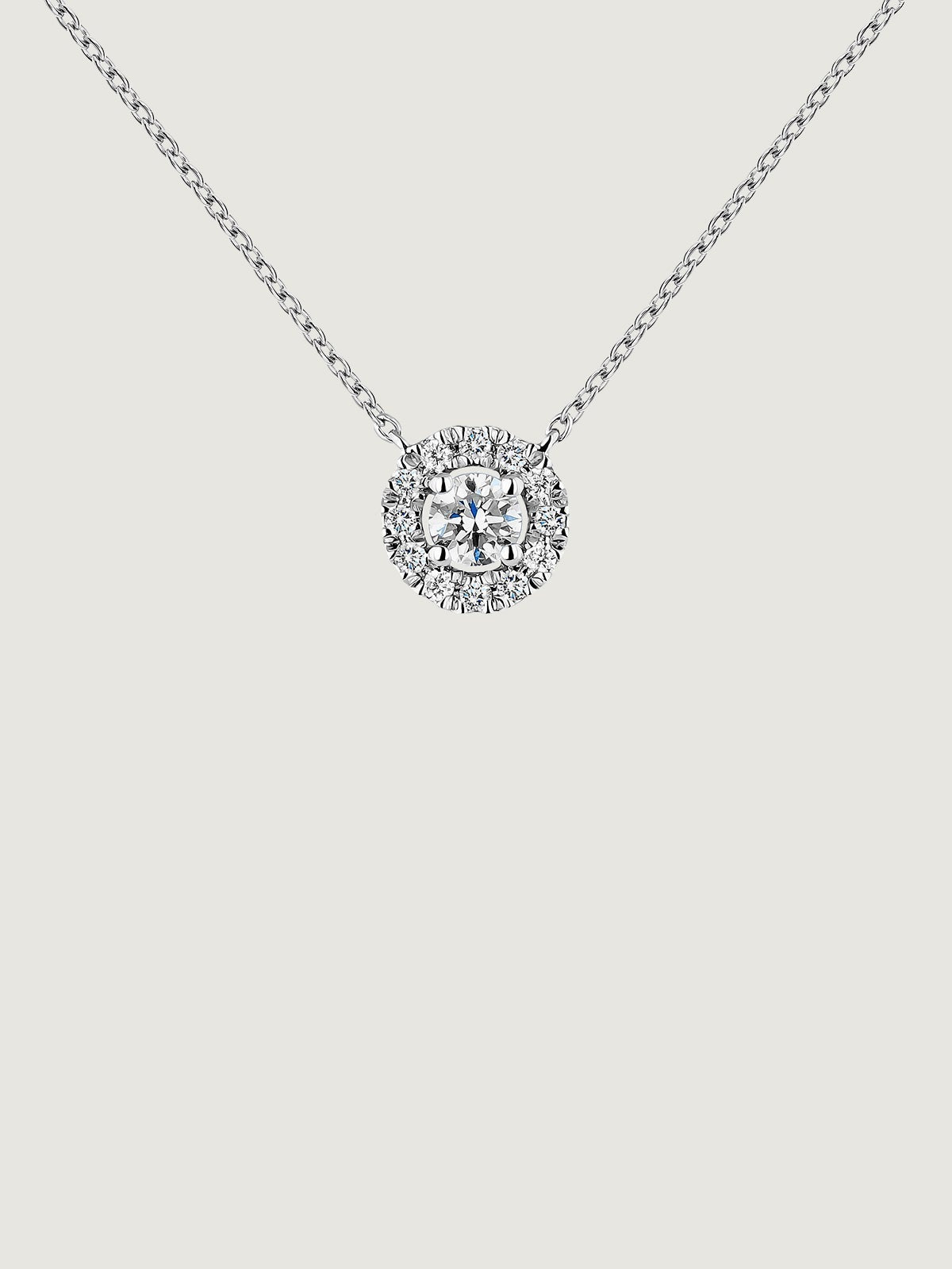 Colgante de oro blanco de 18K con diamante de 0,11cts y orla de diamantes