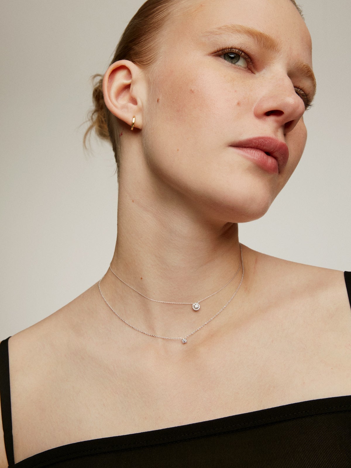 Colgante de oro blanco de 18K con diamante de 0,11cts y orla de diamantes