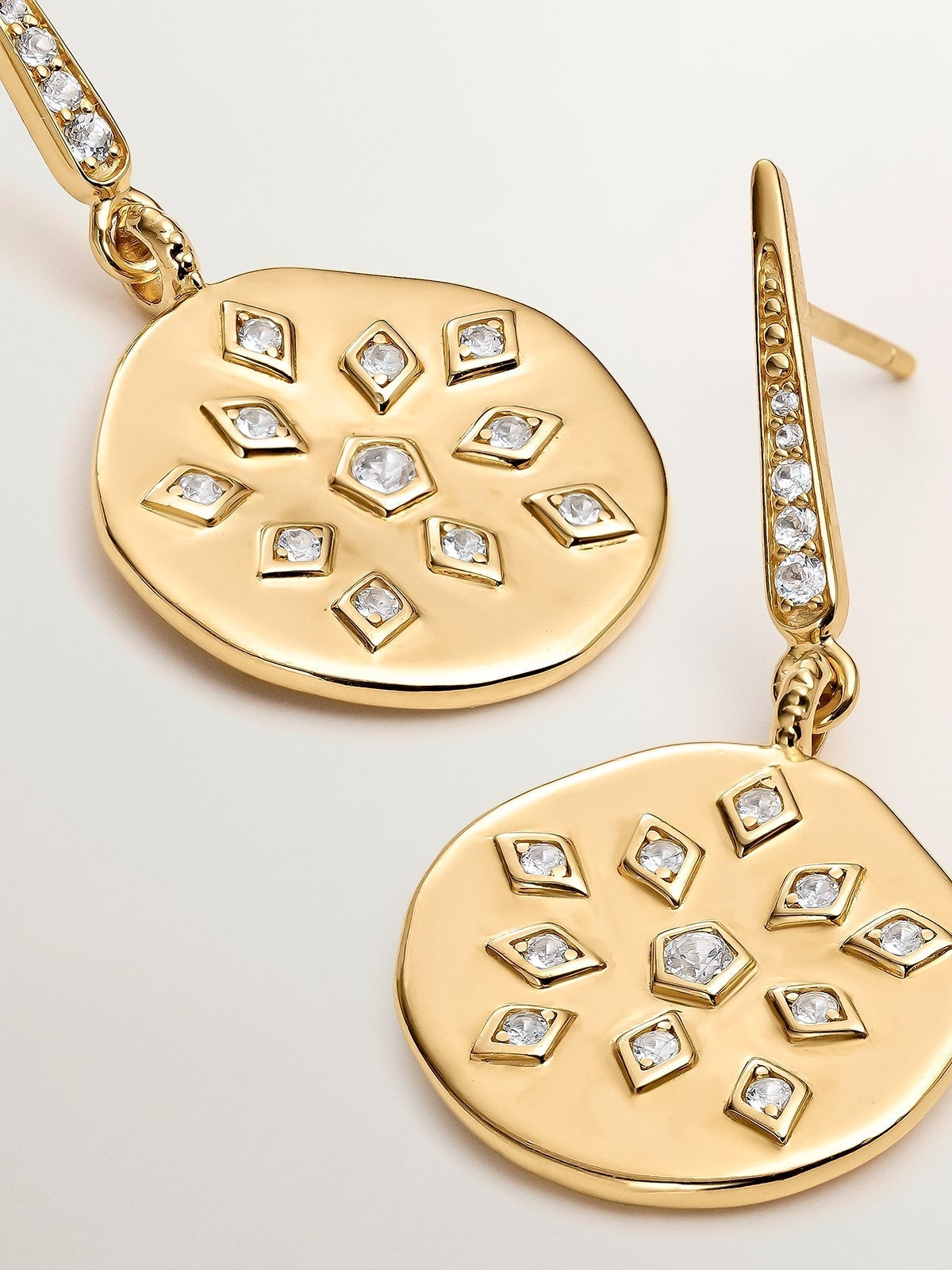 925 silver earrings bathed in 18K yellow gold with an irregular medal shape and white topaz.