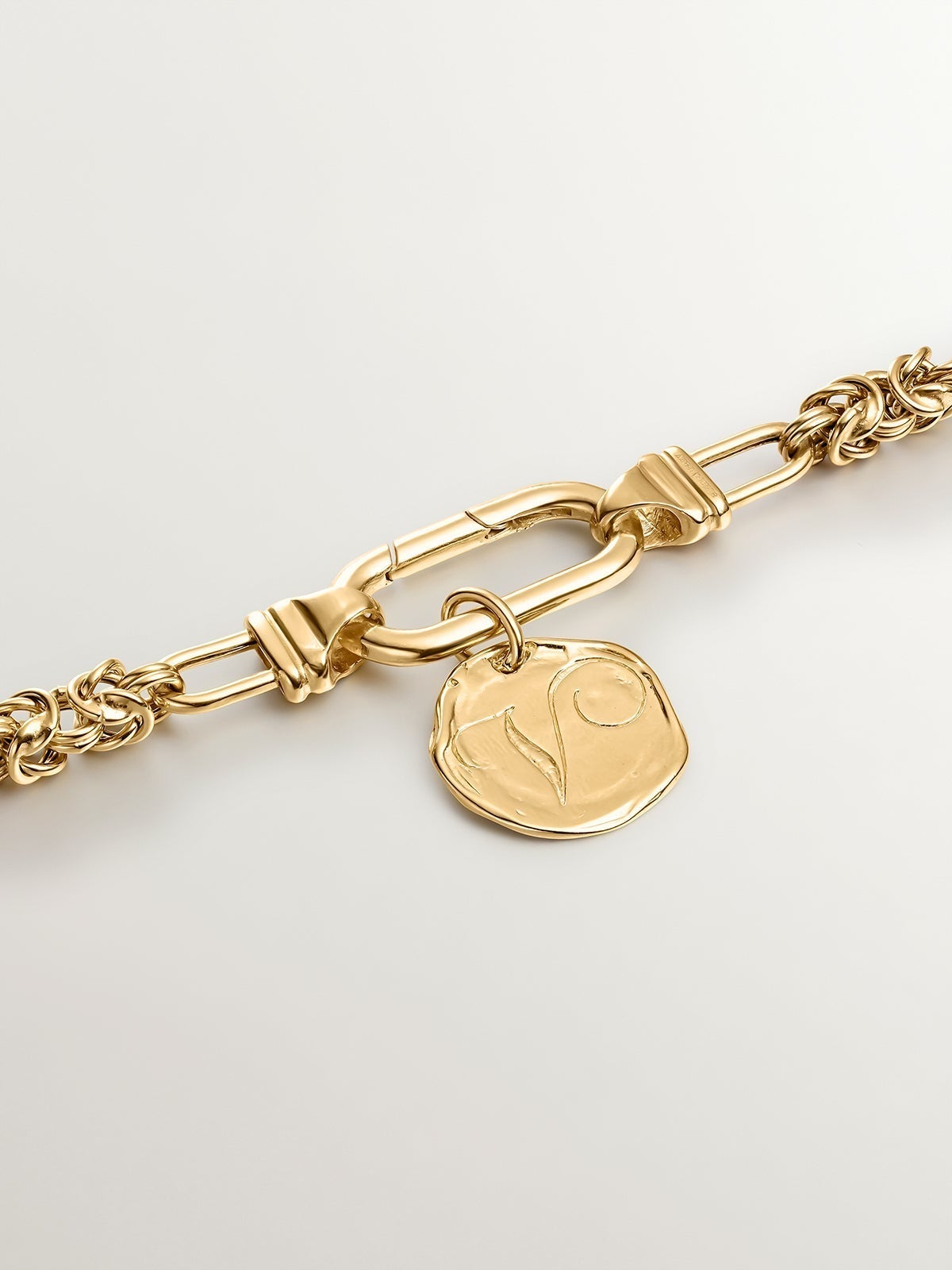 Charm artesanal de plata 925 bañada en oro amarillo de 18K con inicial V