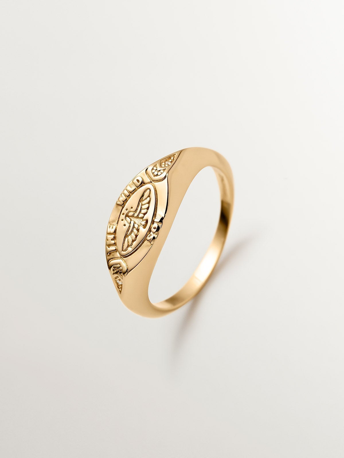 Anillo tipo sello de plata 925 bañada en oro amarillo de 18K con topacios blancos y águila
