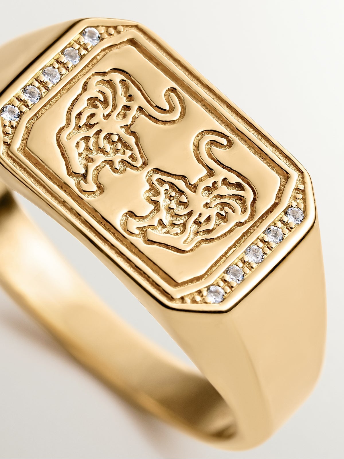 Anillo tipo sello de plata 925 bañada en oro amarillo de 18K con tigres y topacios