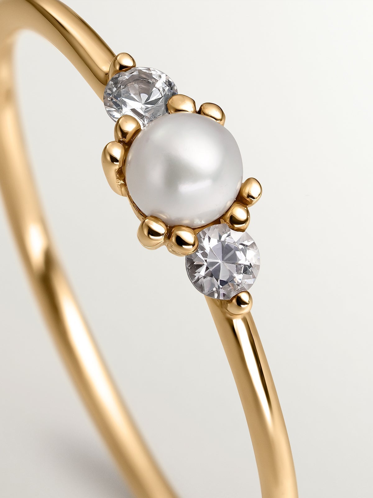 Anillo de oro amarillo de 9K con perla central y zafiros blancos