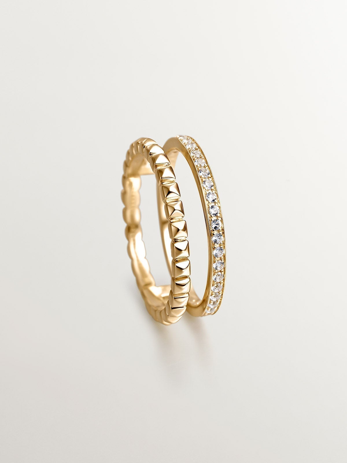 925 Silver double ring bathed in 18K yellow gold with relief and white topaz.