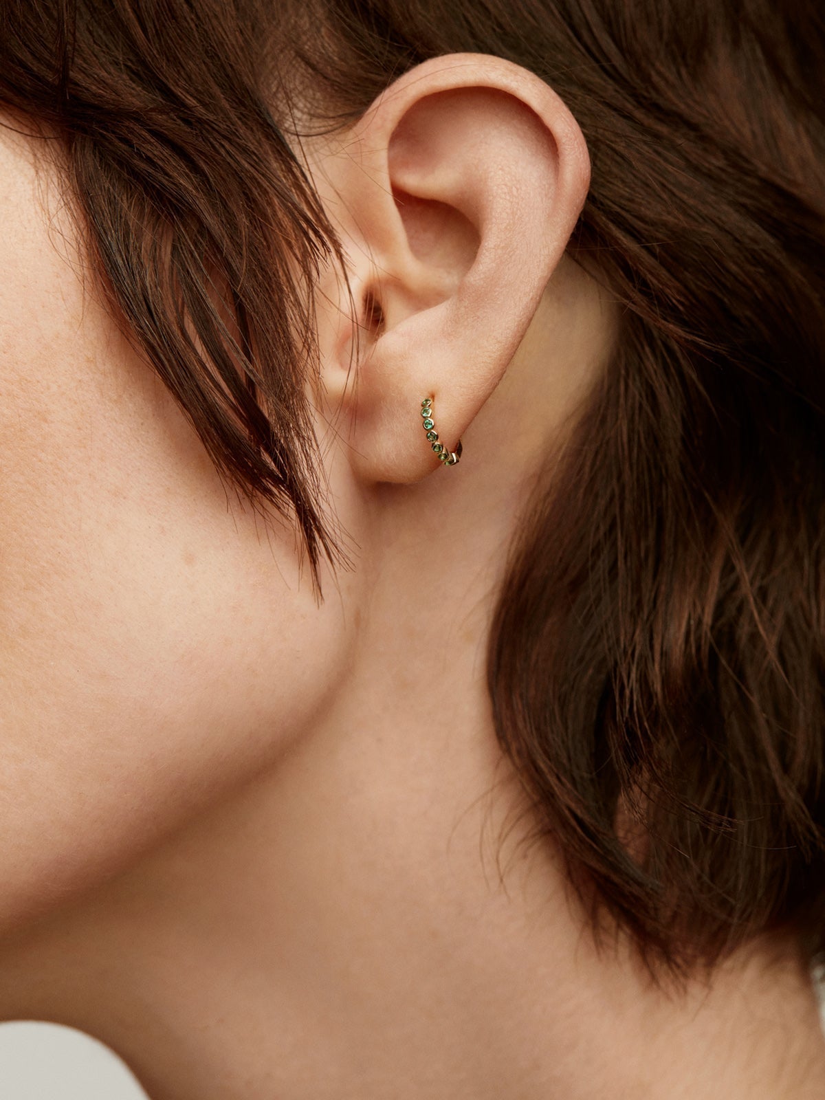 Pendiente individual pequeño de aro de oro amarillo de 9K con esmeraldas