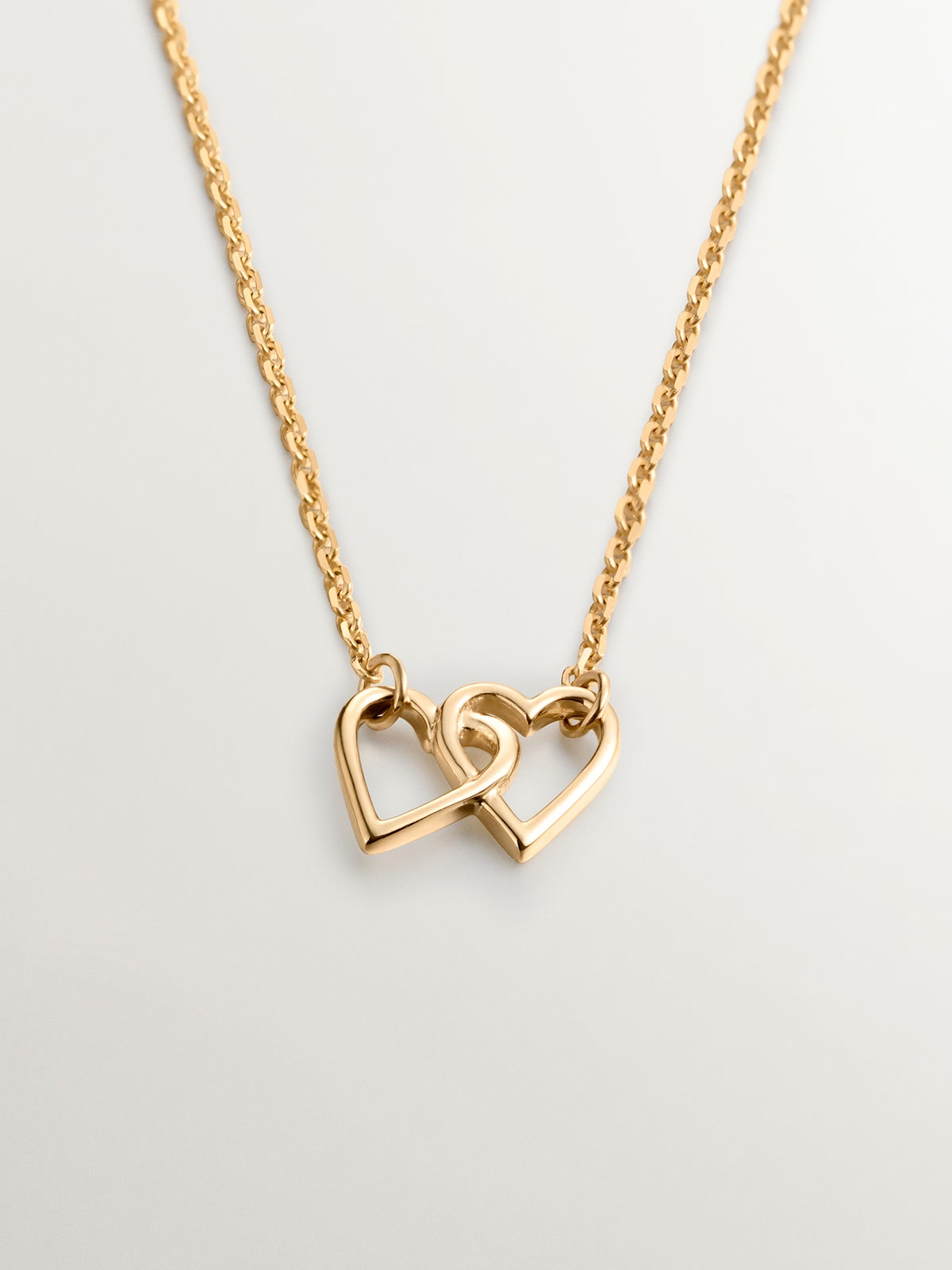 Colgante de oro amarillo de 18K con corazones entrelazados