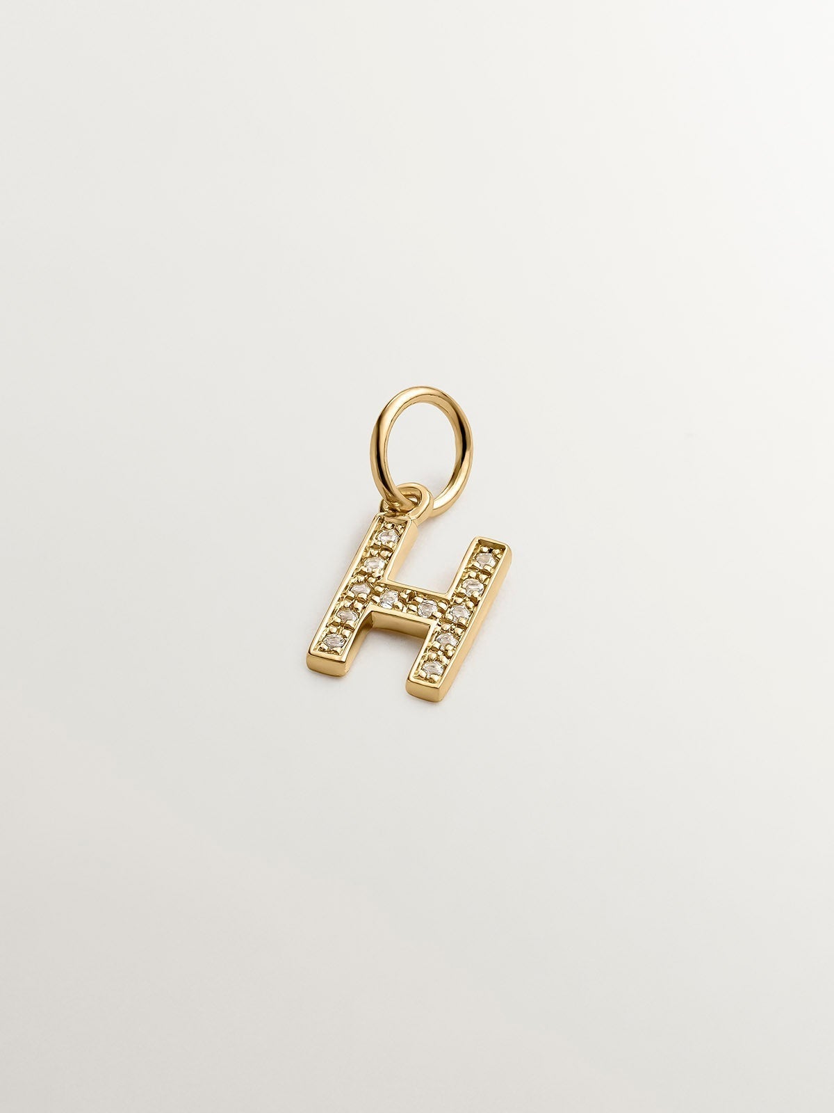 Charm de plata 925 bañada en oro amarillo de 18K y topacios blancos inicial H