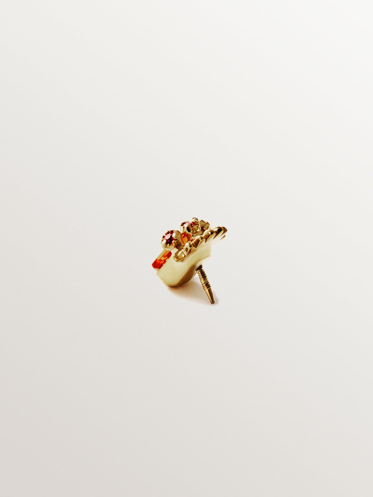 Piercing de oro amarillo de 18K con zafiro naranja central y rubíes rosas
