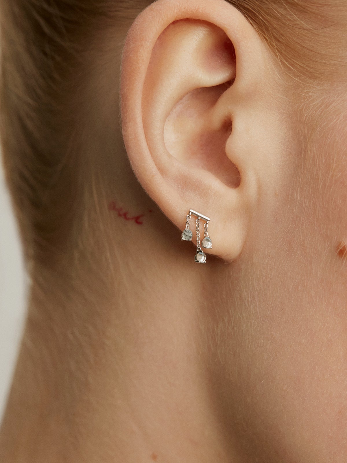 Pendiente individual de oro blanco de 18K con topacios azul sky