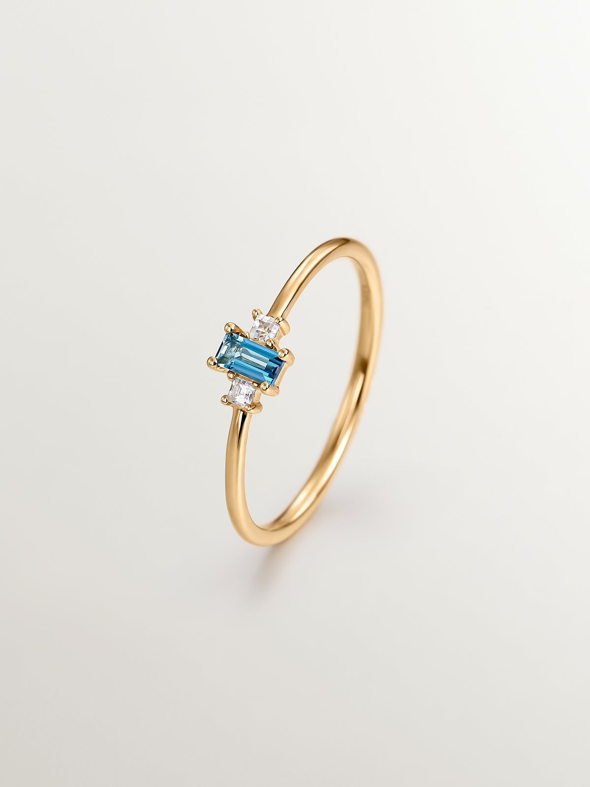 Anillo tresillo de plata 925 bañada en oro amarillo de 18K con topacios azul london y blancos