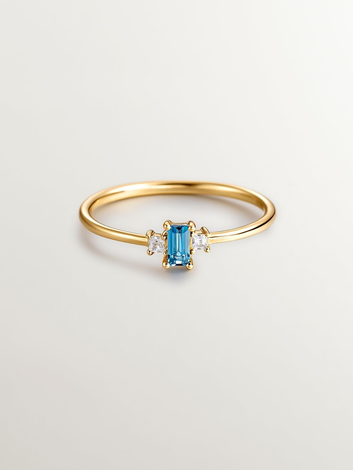 Anillo tresillo de plata 925 bañada en oro amarillo de 18K con topacios azul london y blancos