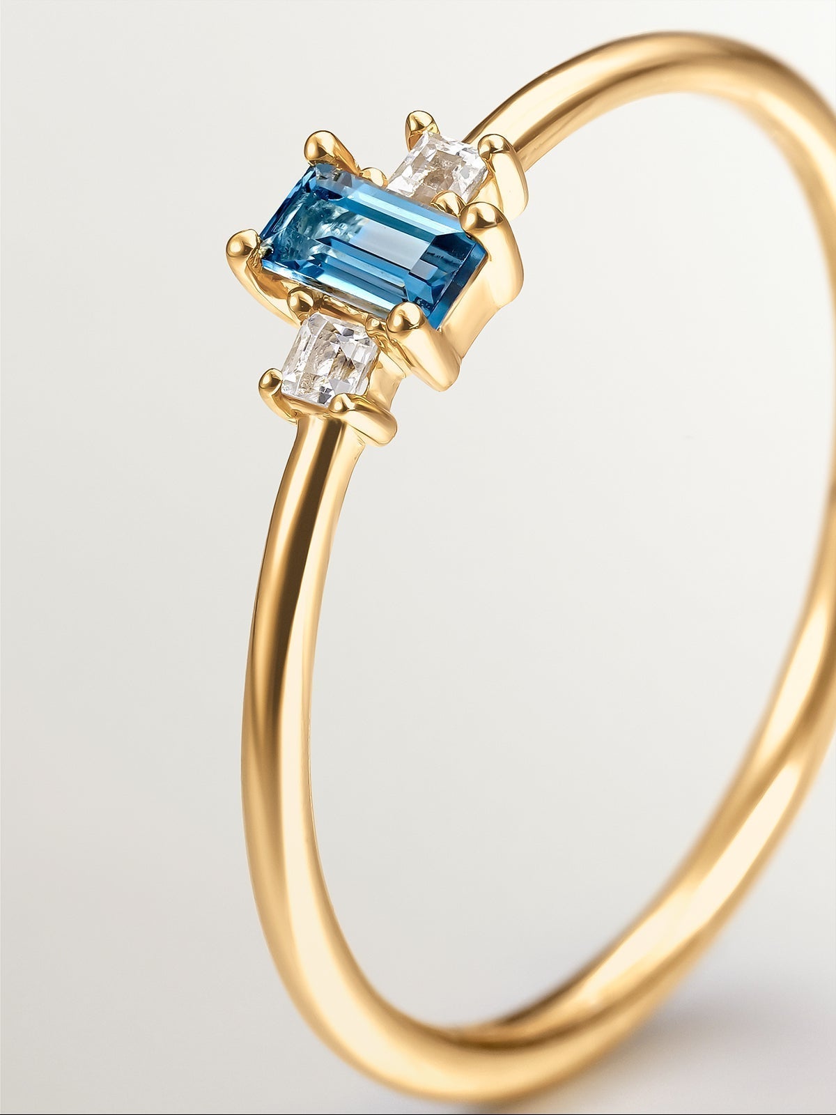 Anillo tresillo de plata 925 bañada en oro amarillo de 18K con topacios azul london y blancos