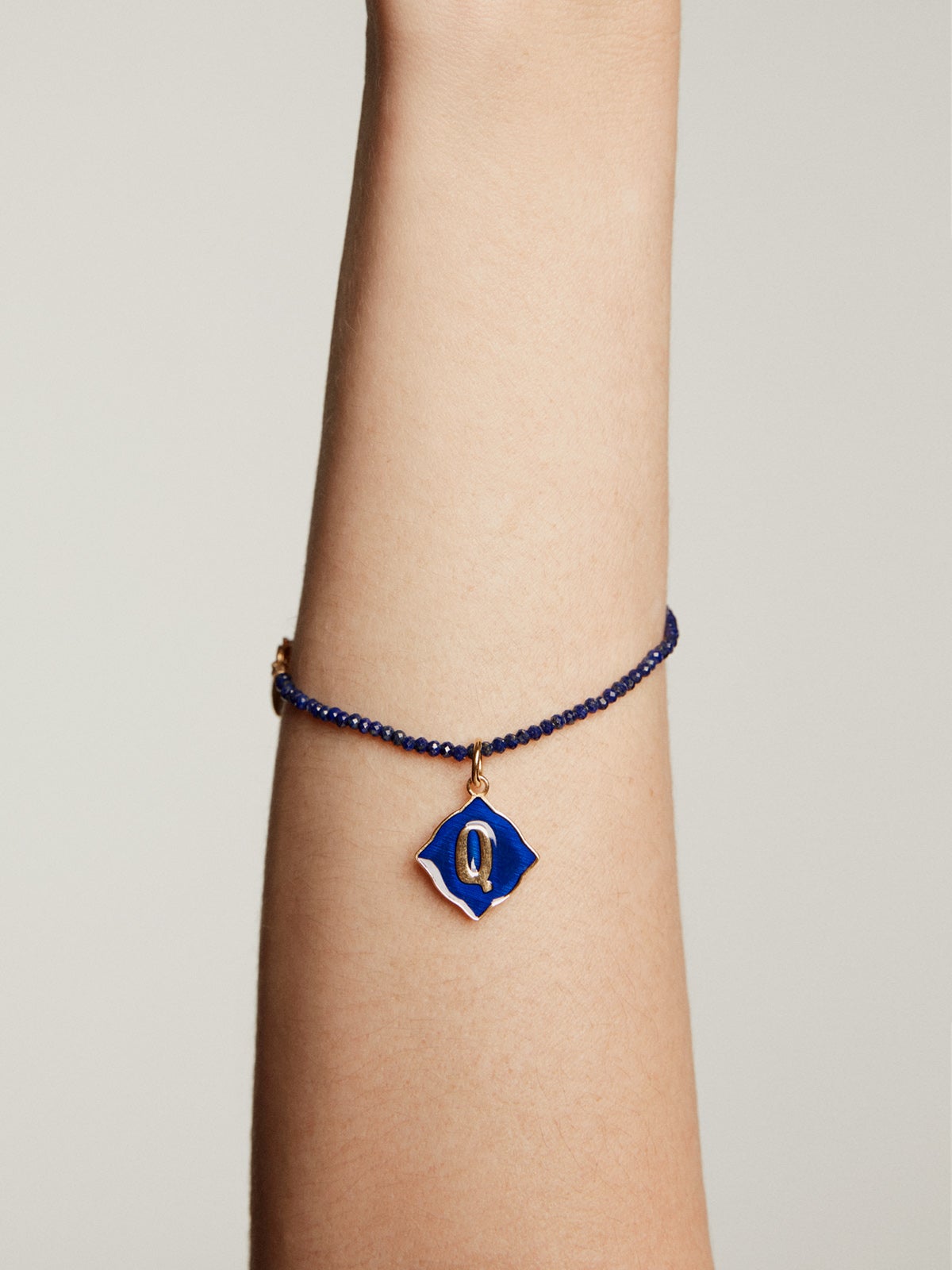Charm de plata 925 bañada en oro amarillo de 18K con inicial Q y esmalte azul con forma de rombo irregular