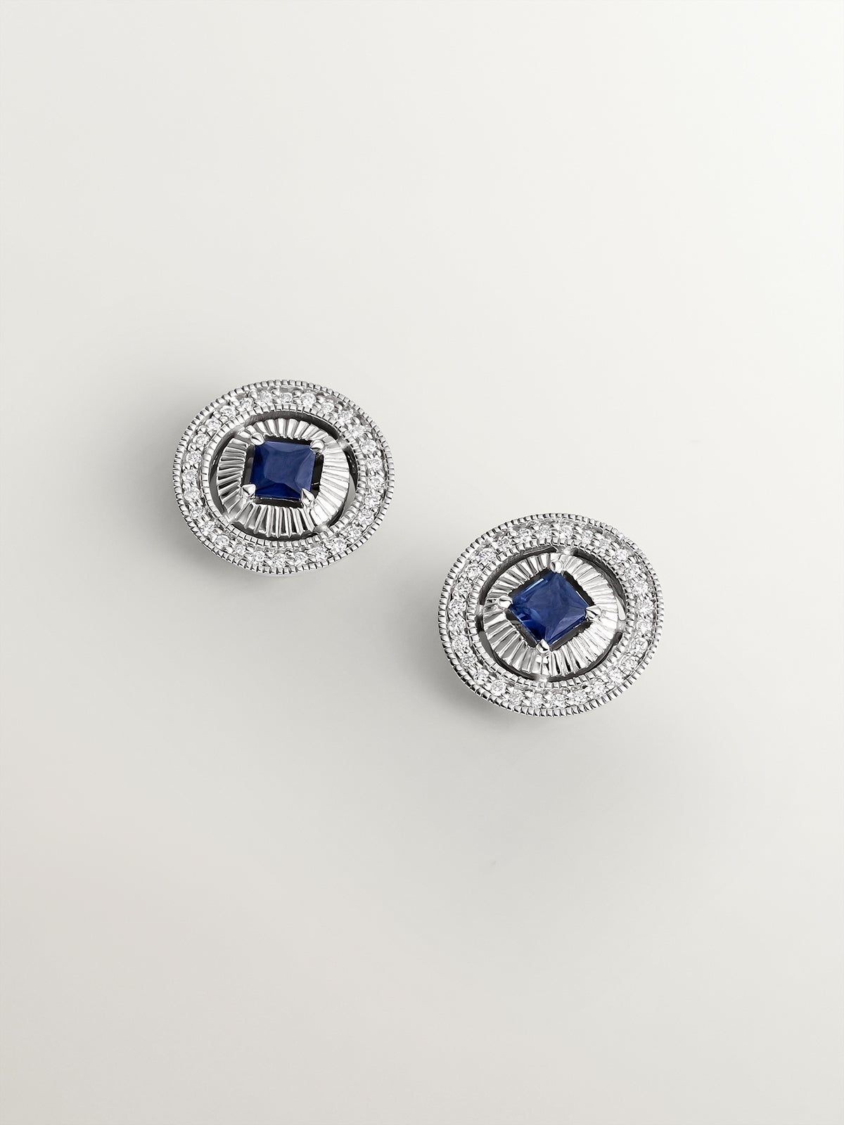 Pendientes de oro blanco de 18K con diamantes en talla brillante y zafiros azules en talla princesa