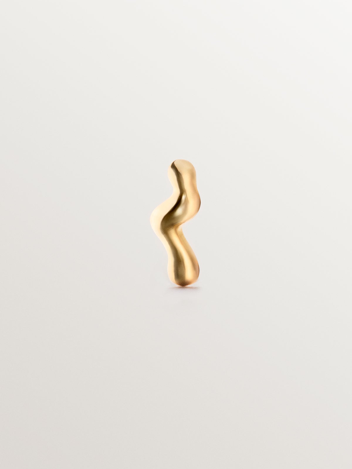 Piercing individual de oro amarillo de 18K con forma orgánica de ola.