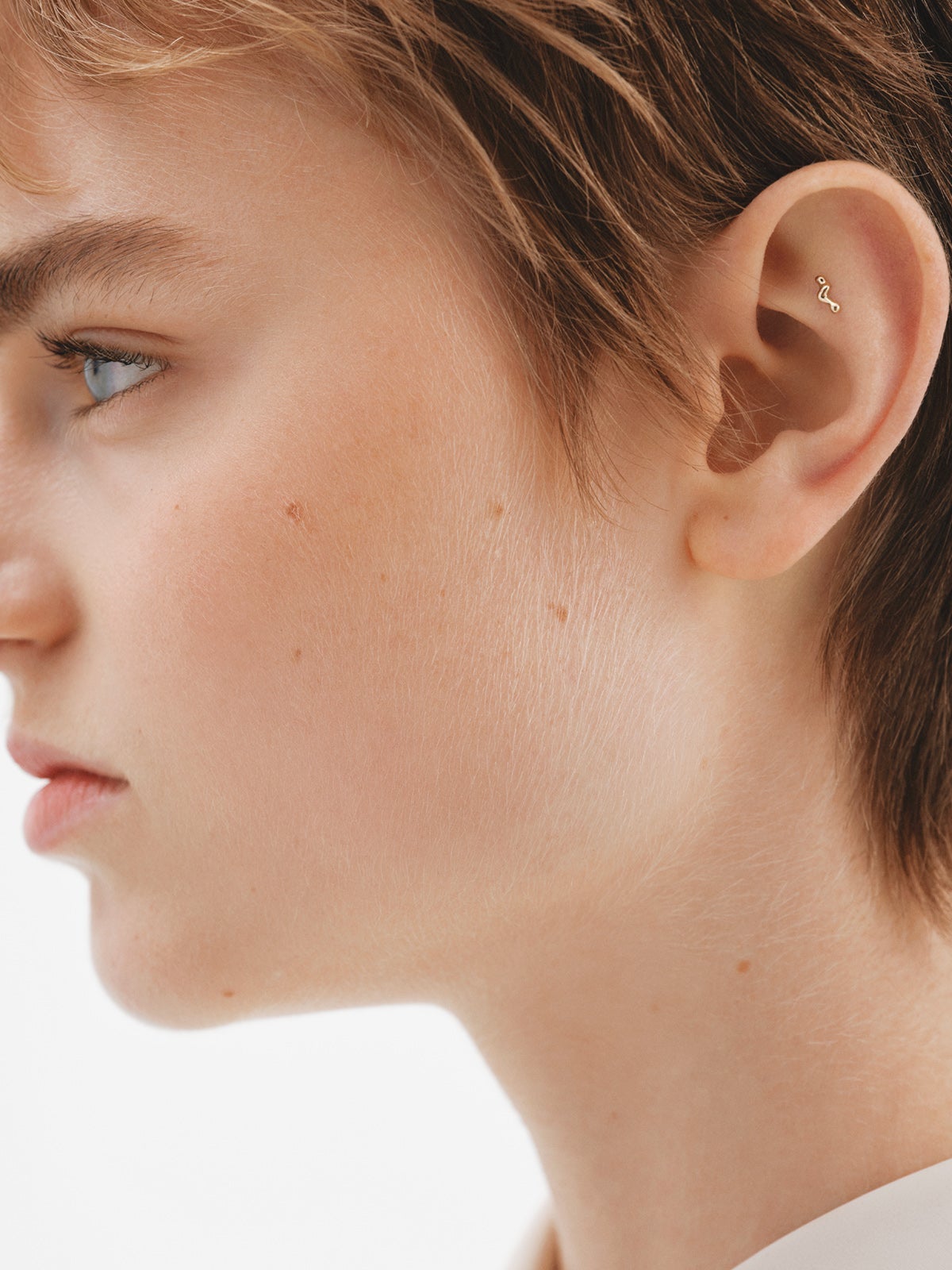 Piercing individual de oro amarillo de 18K con forma orgánica de ola.